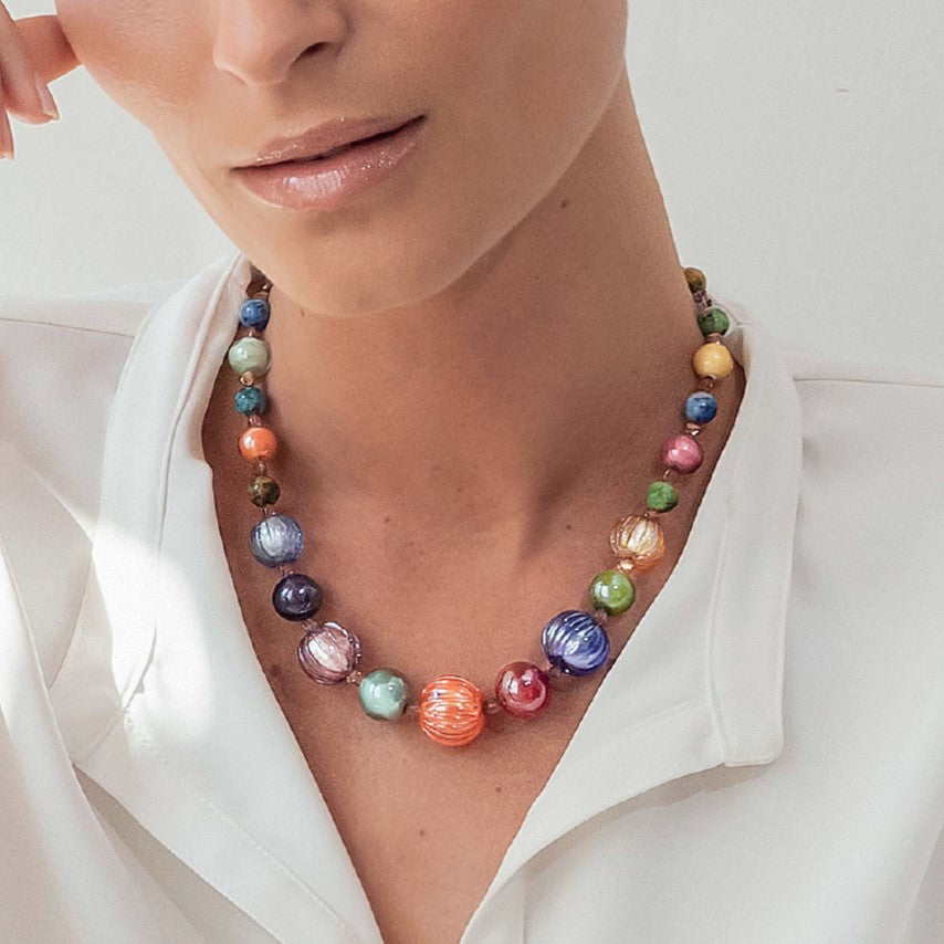 Model wearing MURRINAMURANO Venezia necklace  from the Gea Collection, handcrafted in Original Murano glass, 18KT Gold Finish or Rhodium finish, over Brass. Made in Italy – murrinamurano.us