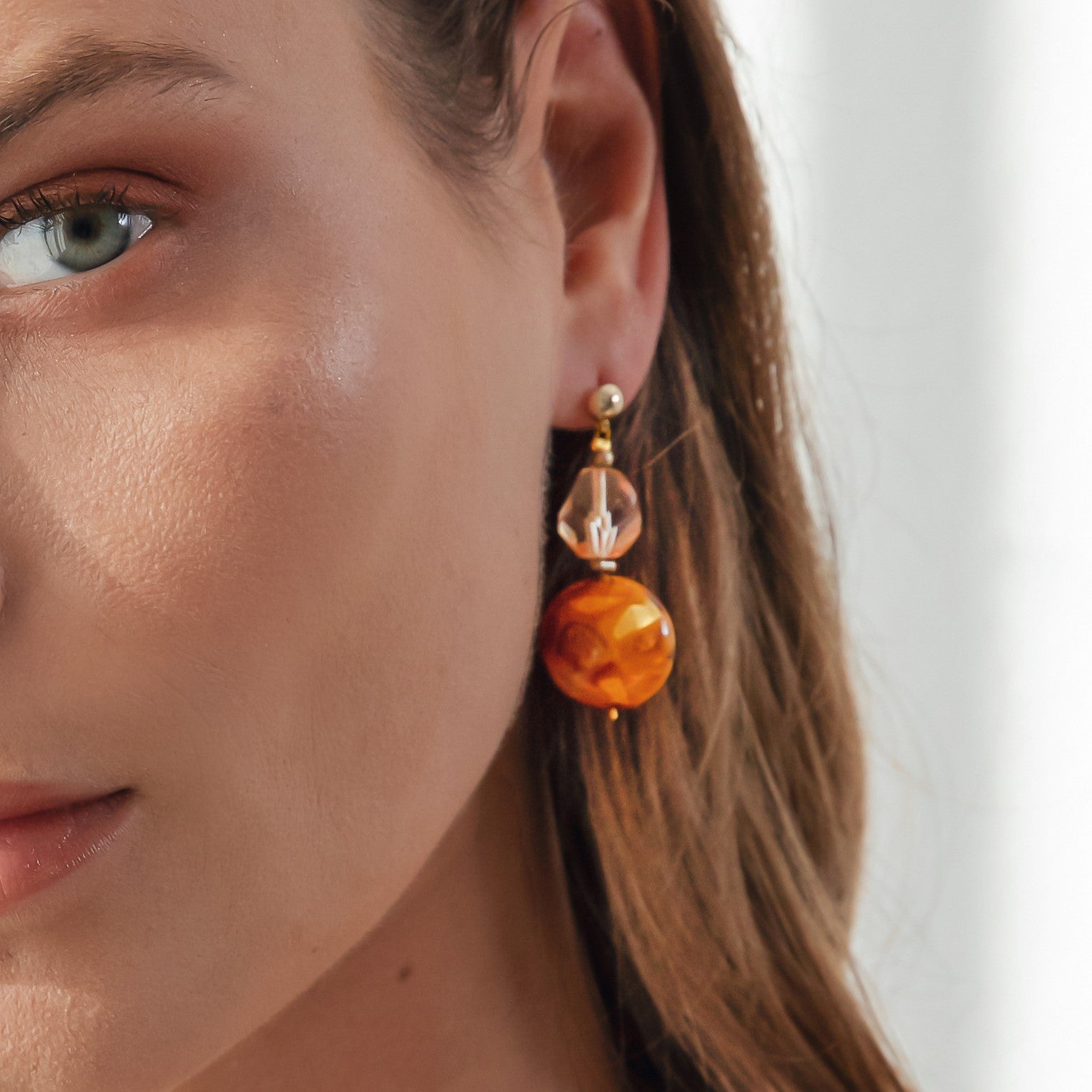 Model wearing MURRINAMURANO Venezia earrings from the Aura Collection, handcrafted in Original Murano glass, 18KT Gold Finish or Rhodium finish, over Brass. Made in Italy – murrinamurano.us