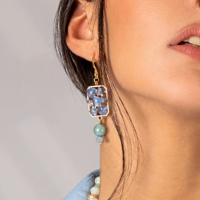 Model wearing MURRINAMURANO Venezia earrings from the Zefiro Collection, handcrafted in Original Murano glass, 18KT Gold Finish or Rhodium finish, over Brass. Made in Italy – murrinamurano.us