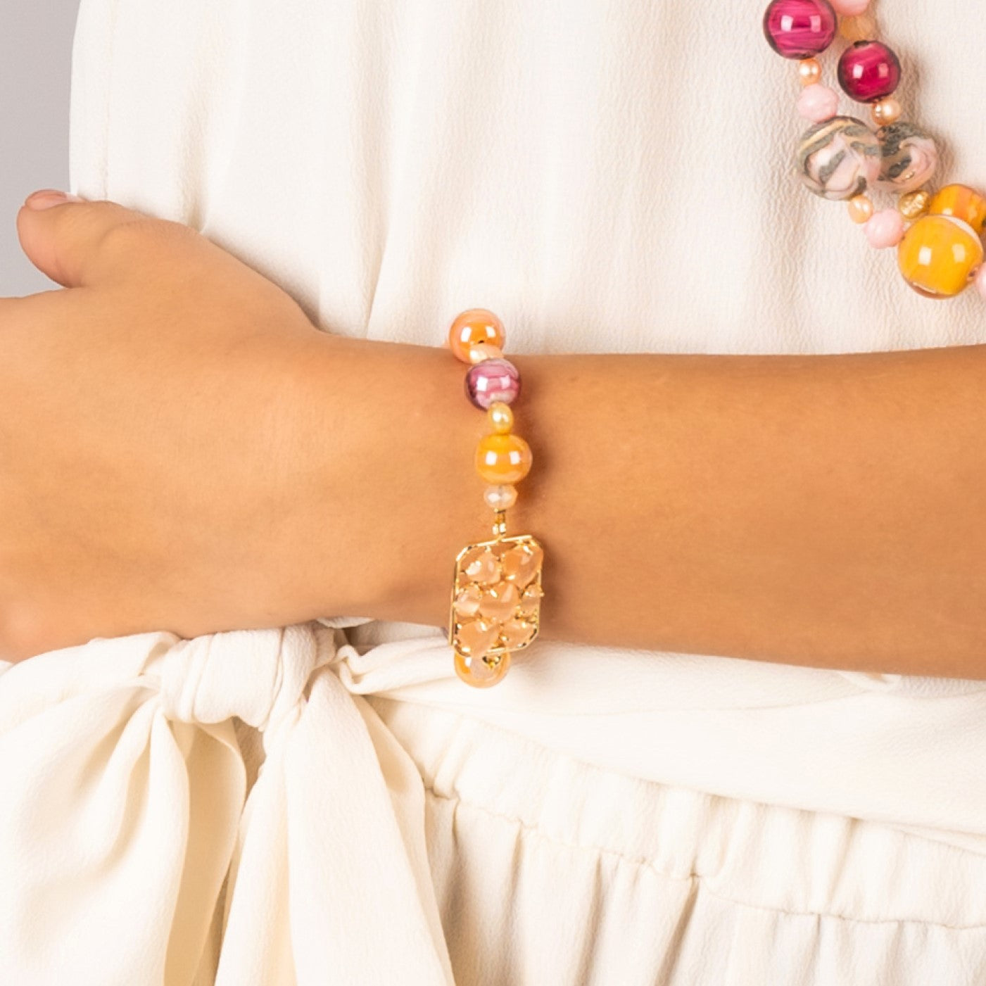 Model wearing MURRINAMURANO Venezia bracelet from the Zefiro Collection, handcrafted in Original Murano glass, 18KT Gold Finish or Rhodium finish, over Brass. Made in Italy – murrinamurano.us