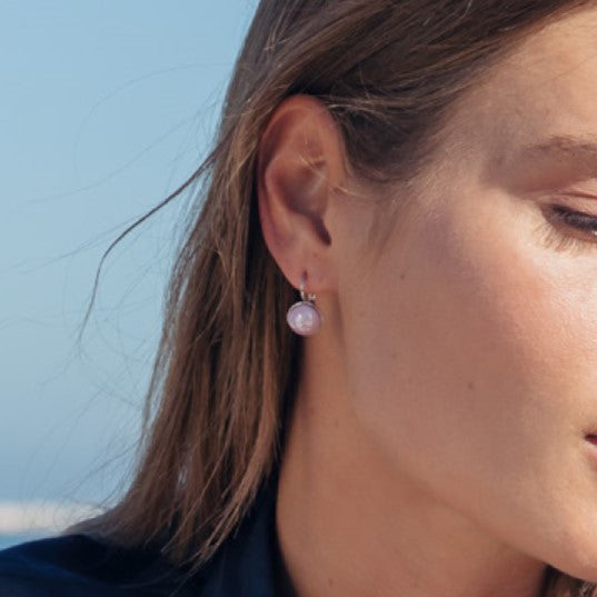 Model wearing MURRINAMURANO Venezia earrings from the Seaside Serenity Collection, handcrafted in Original Murano glass, 18KT Gold Finish or Rhodium finish, over Brass. Made in Italy – murrinamurano.us