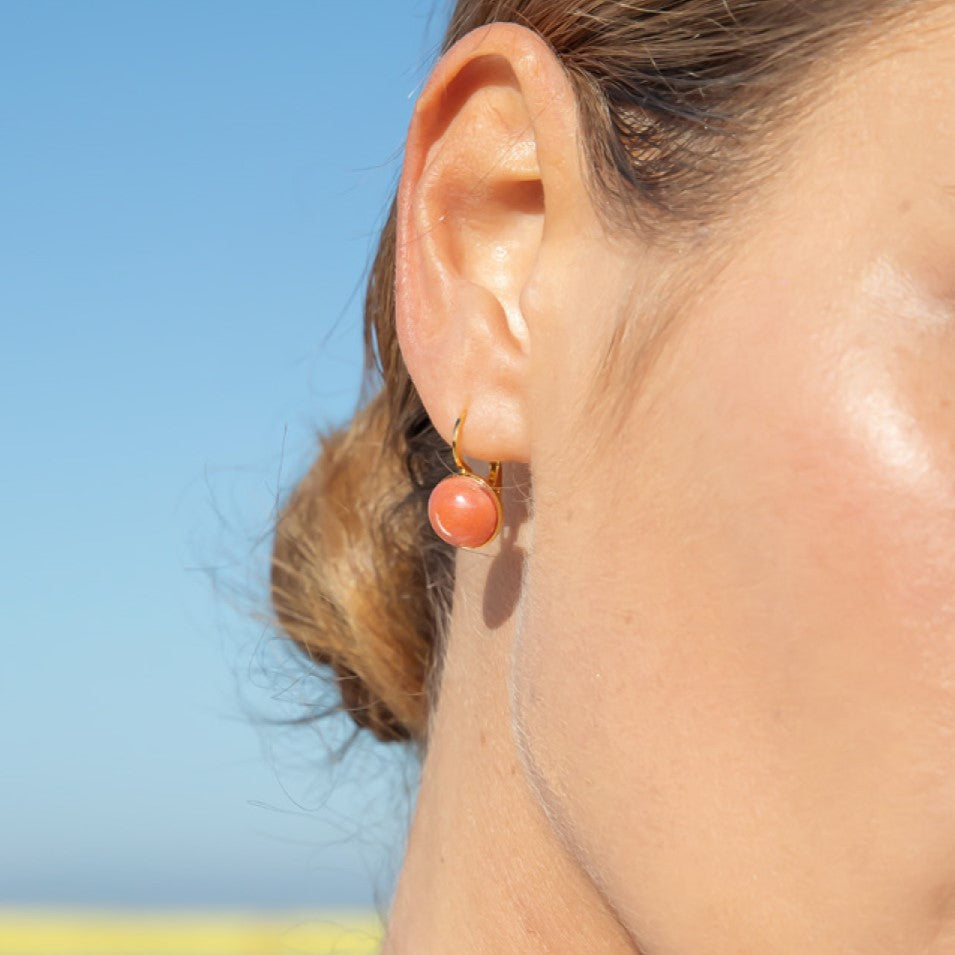 Model wearing MURRINAMURANO Venezia earrings from the Seaside Serenity Collection, handcrafted in Original Murano glass, 18KT Gold Finish or Rhodium finish, over Brass. Made in Italy – murrinamurano.us