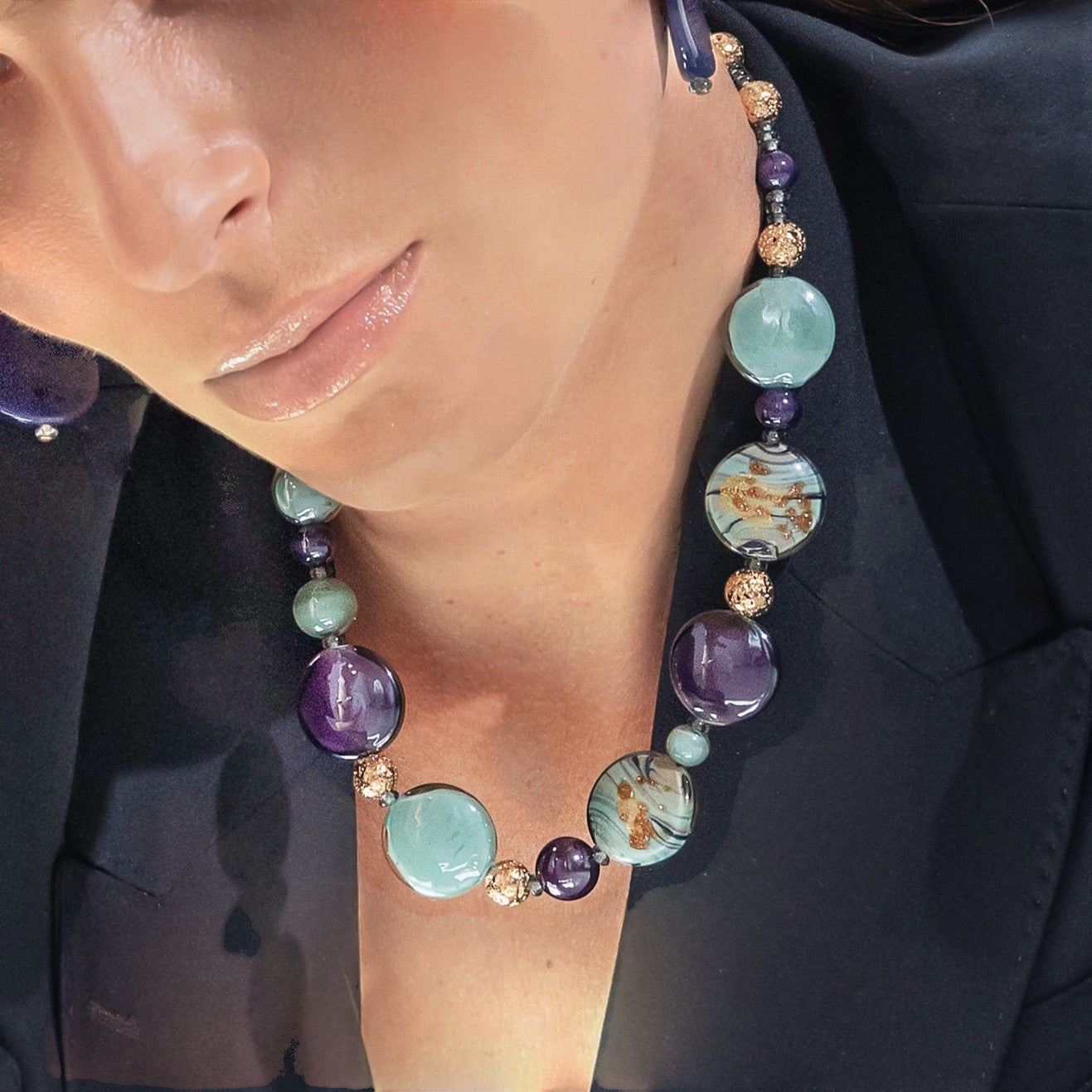 Model wearing MURRINAMURANO Venezia necklace from the Gaia Collection, handcrafted in Original Murano glass, 18KT Gold Finish over Stainless Steel. Made in Italy – murrinamurano.us