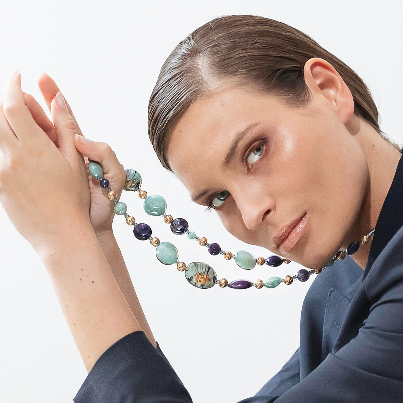 Model wearing MURRINAMURANO Venezia necklace from the Gaia Collection, handcrafted in Original Murano glass, 18KT Gold Finish or Rhodium finish, over Brass. Made in Italy – murrinamurano.us