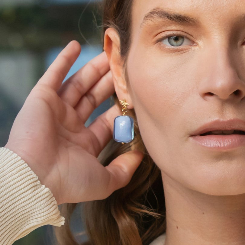 Model wearing MURRINAMURANO Venezia Earrings from the Jasmin Collection, handcrafted in Original Murano glass, 18KT Gold Finish or Rhodium finish, over Brass. Made in Italy – murrinamurano.us