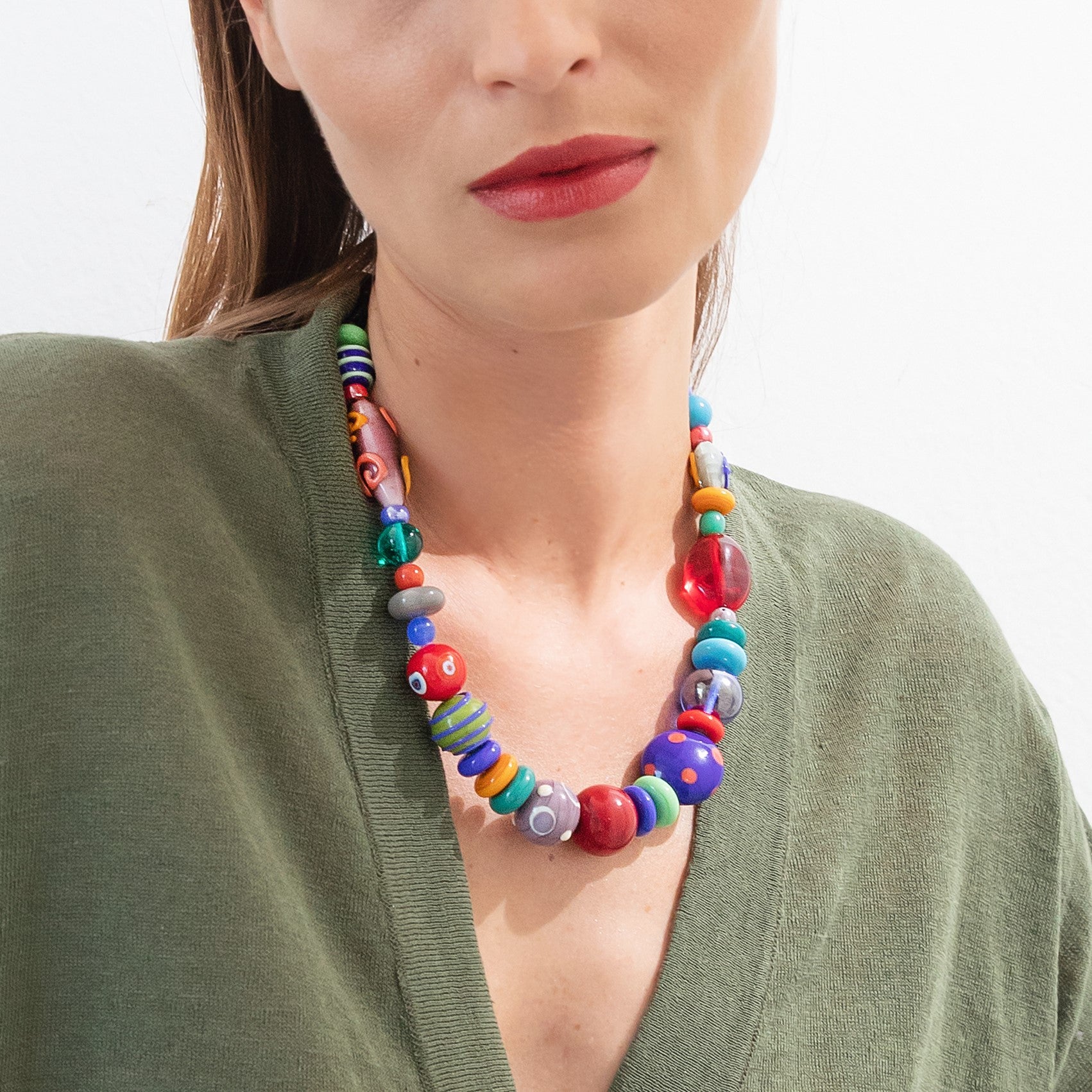 Model wearing MURRINAMURANO Venezia necklace from the Elettra Collection, handcrafted in Original Murano glass, 18KT Gold Finish or Rhodium finish, over Brass. Made in Italy – murrinamurano.us