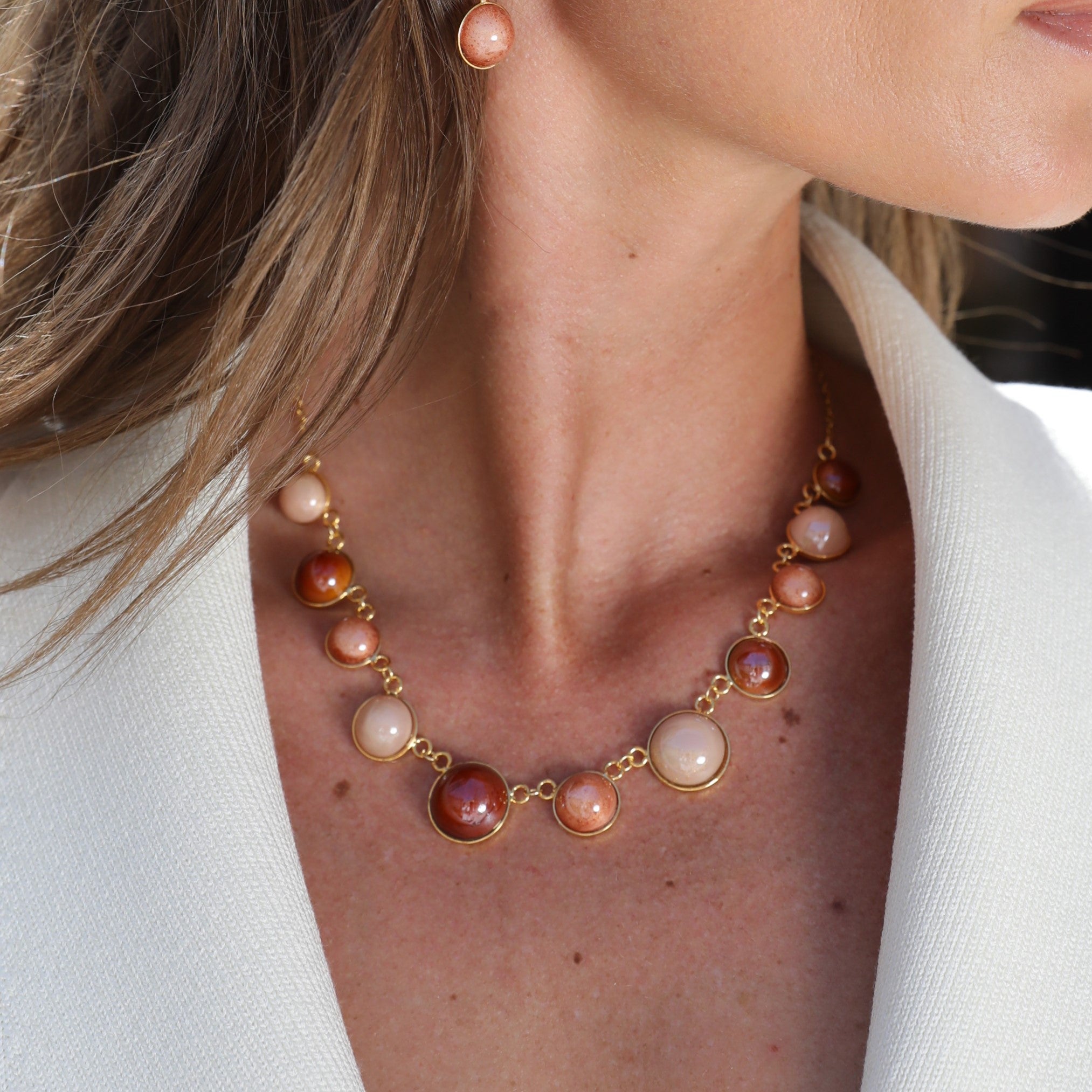 Model wearing MURRINAMURANO Venezia necklace from the Audrey Collection, handcrafted in Original Murano glass, 18KT Gold Finish or Rhodium finish, over Brass. Made in Italy – murrinamurano.us