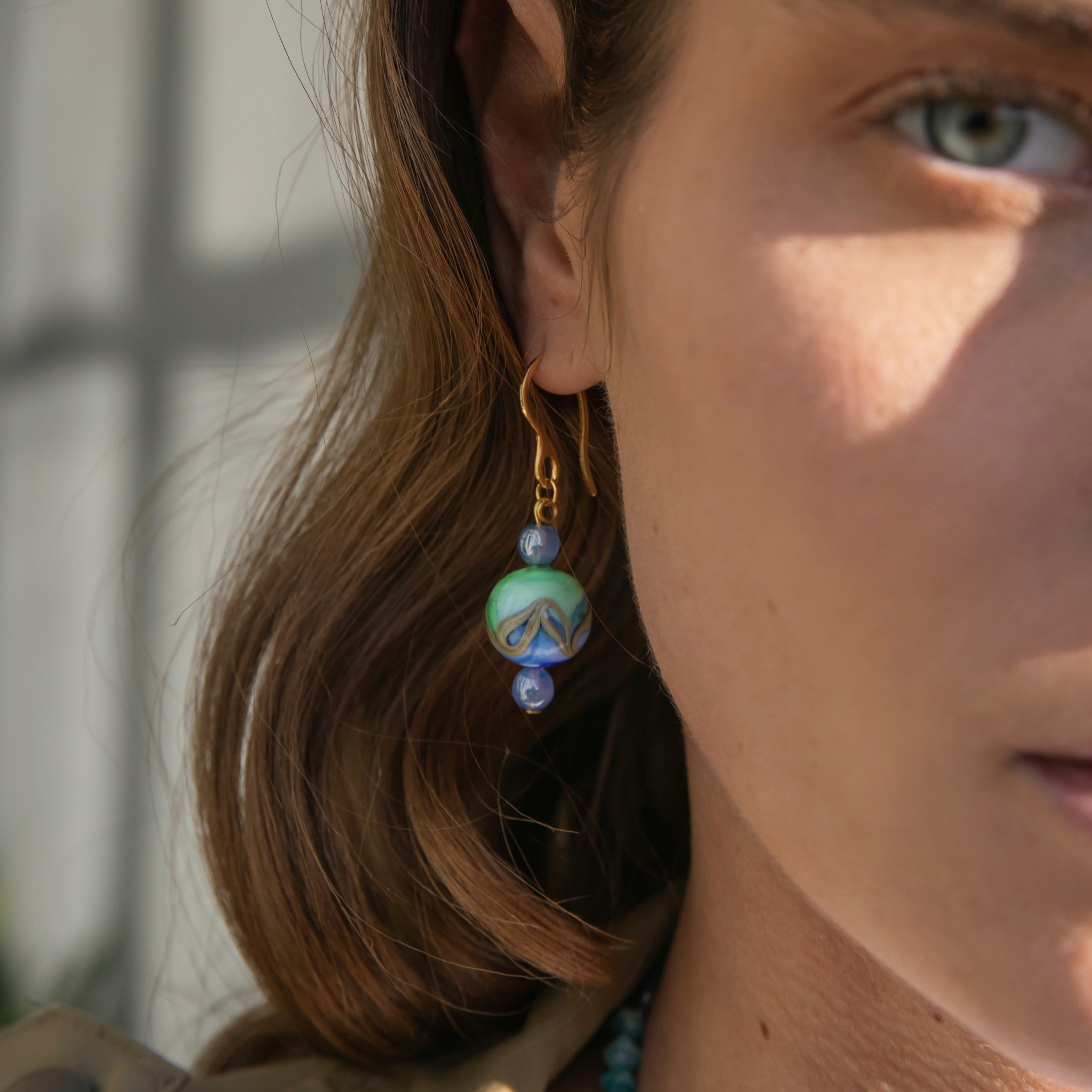 Model wearing MURRINAMURANO Venezia earrings  from the Malika Collection, handcrafted in Original Murano glass, with 18KT Gold Finish over Brass and Stainless Steel hooks