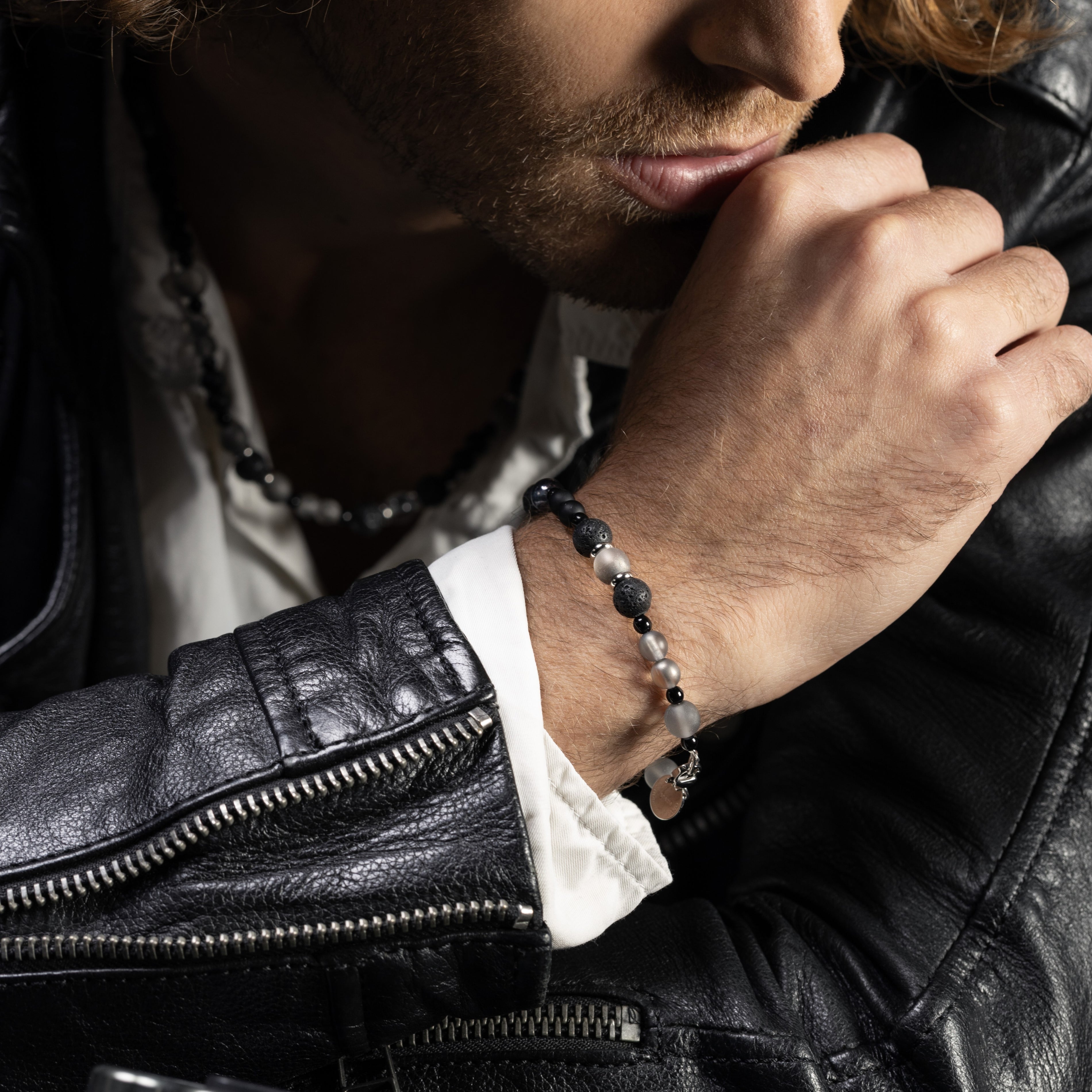 Man wearing a Glera Collection men’s bracelet with lava stone and malachite, rhodium finish over stainless steel and brass, 20 cm length.