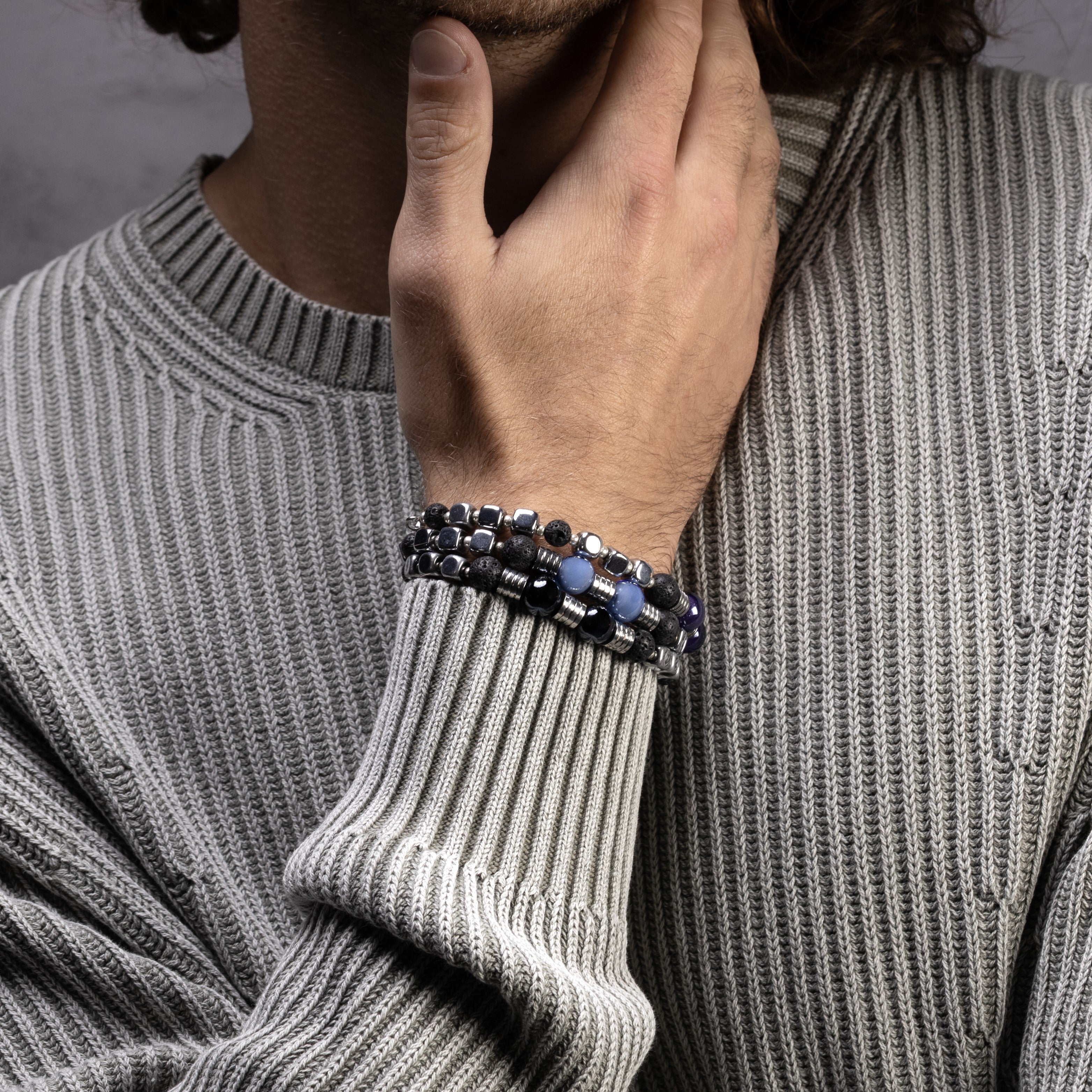 Lagrein Collection - Person wearing a gray sweater with a bracelet on a neutral background