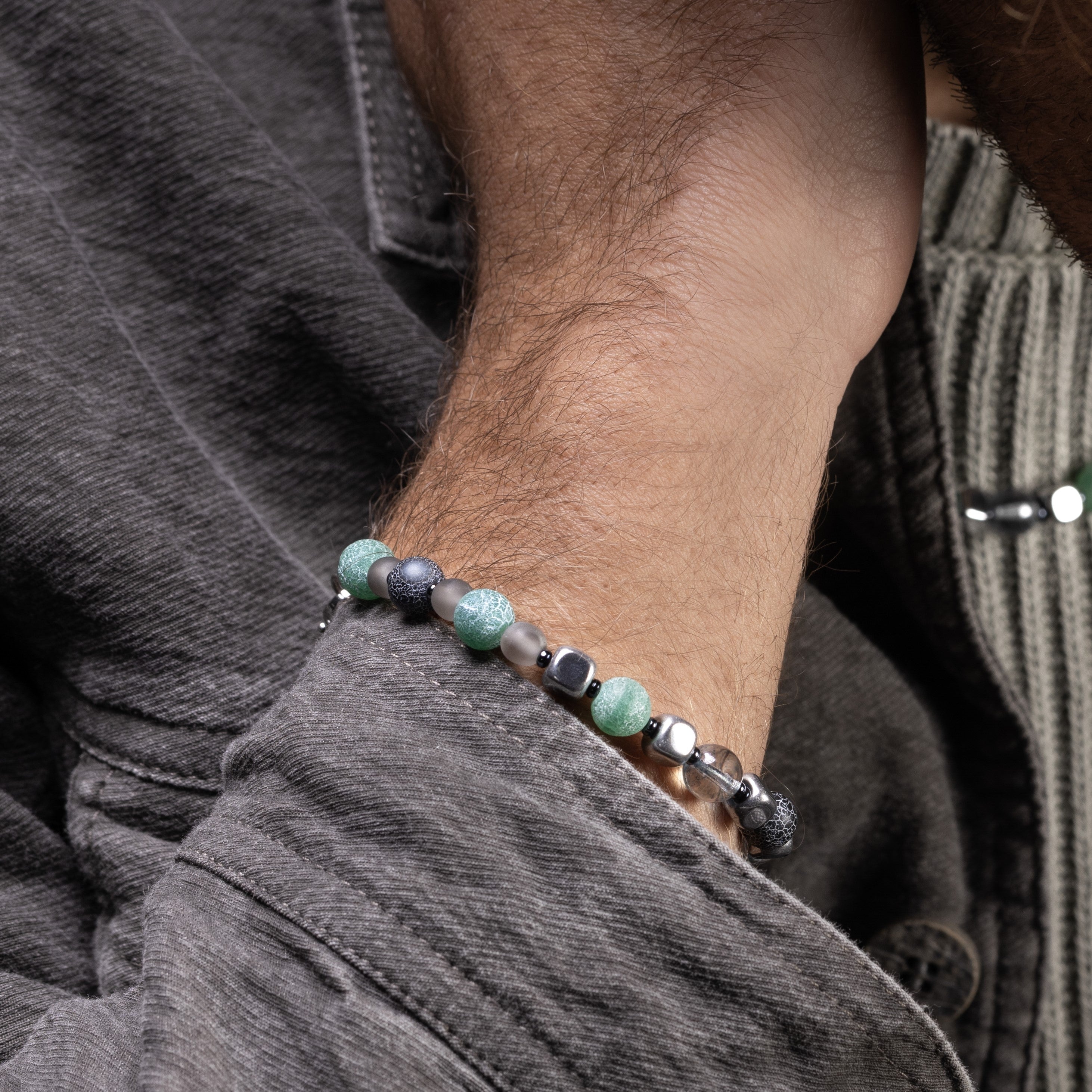 Close-up of a wrist wearing a Babich men’s bracelet with agate and hematite stones, rhodium finish over stainless steel and brass, 7.9 inches, contemporary Italian design.