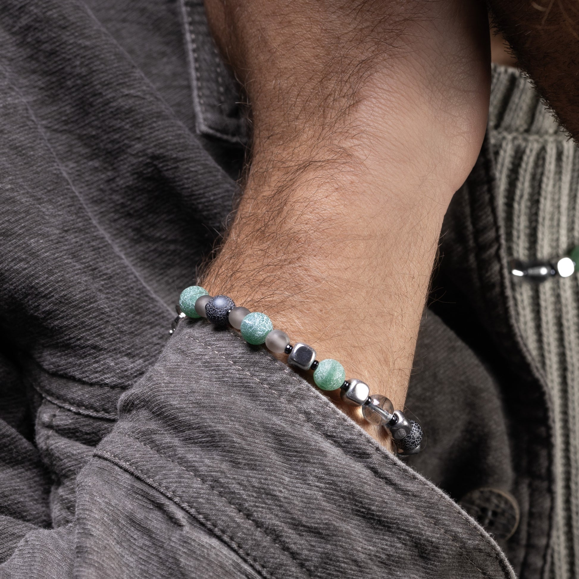 Close-up of a wrist wearing a Babich men’s bracelet with agate and hematite stones, rhodium finish over stainless steel and brass, 7.9 inches, contemporary Italian design.