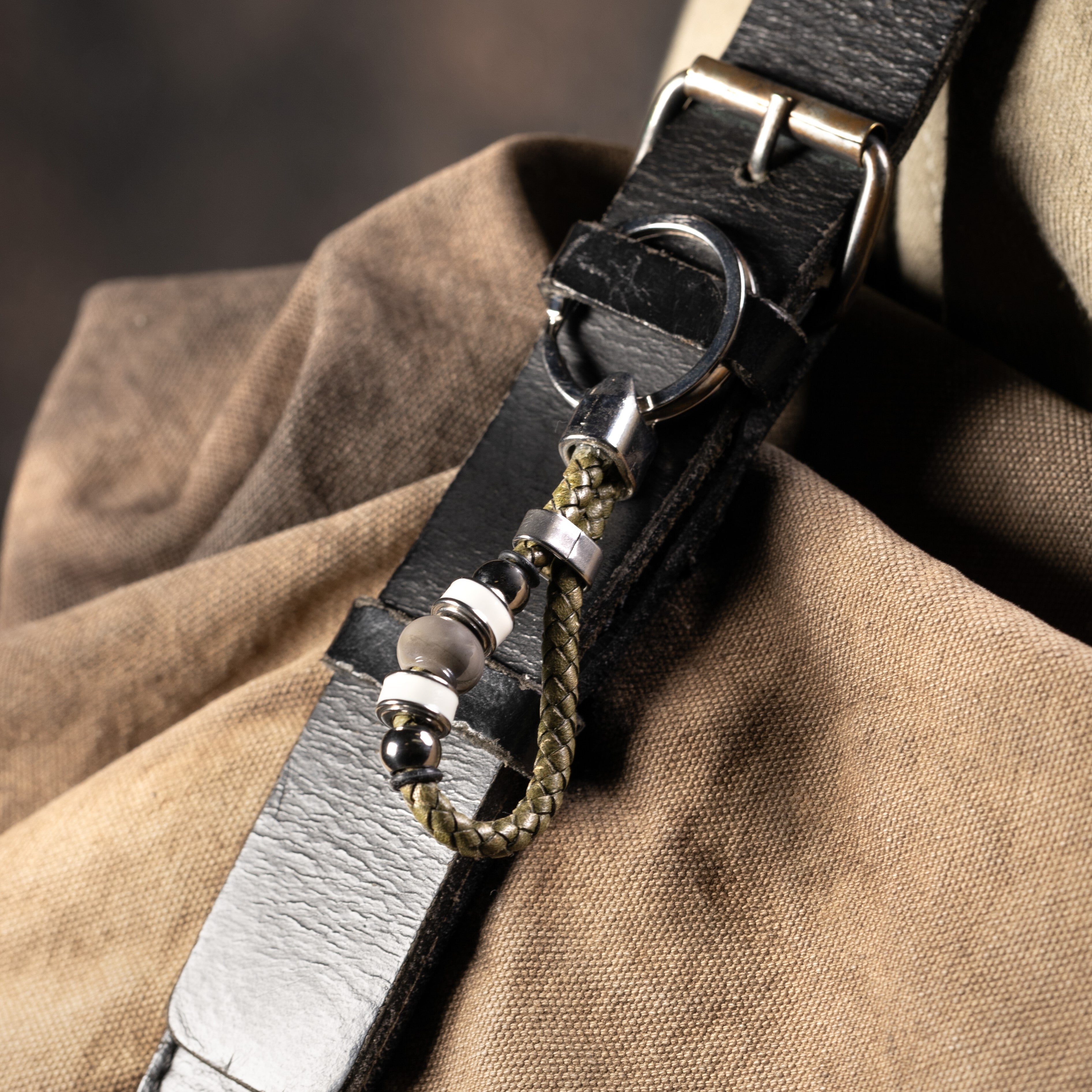 Close-up of a Flare Collection men’s keychain with Murano Glass, braided leather, rhodium finish over stainless steel, brass and silicone details, 10 cm length.