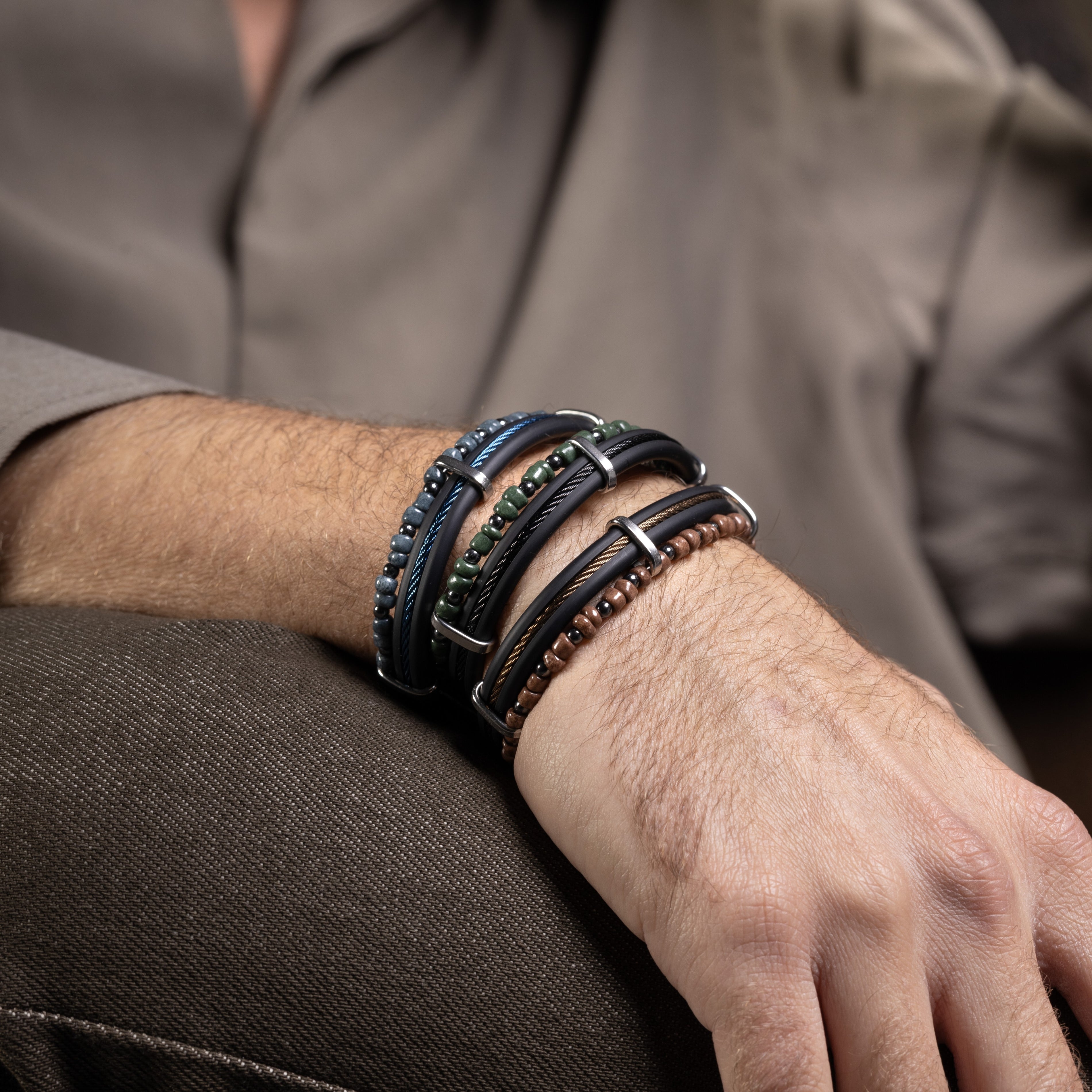 Void Collection - Murano Glass - Close-up of a person's wrist wearing multiple leather bracelets with a neutral background