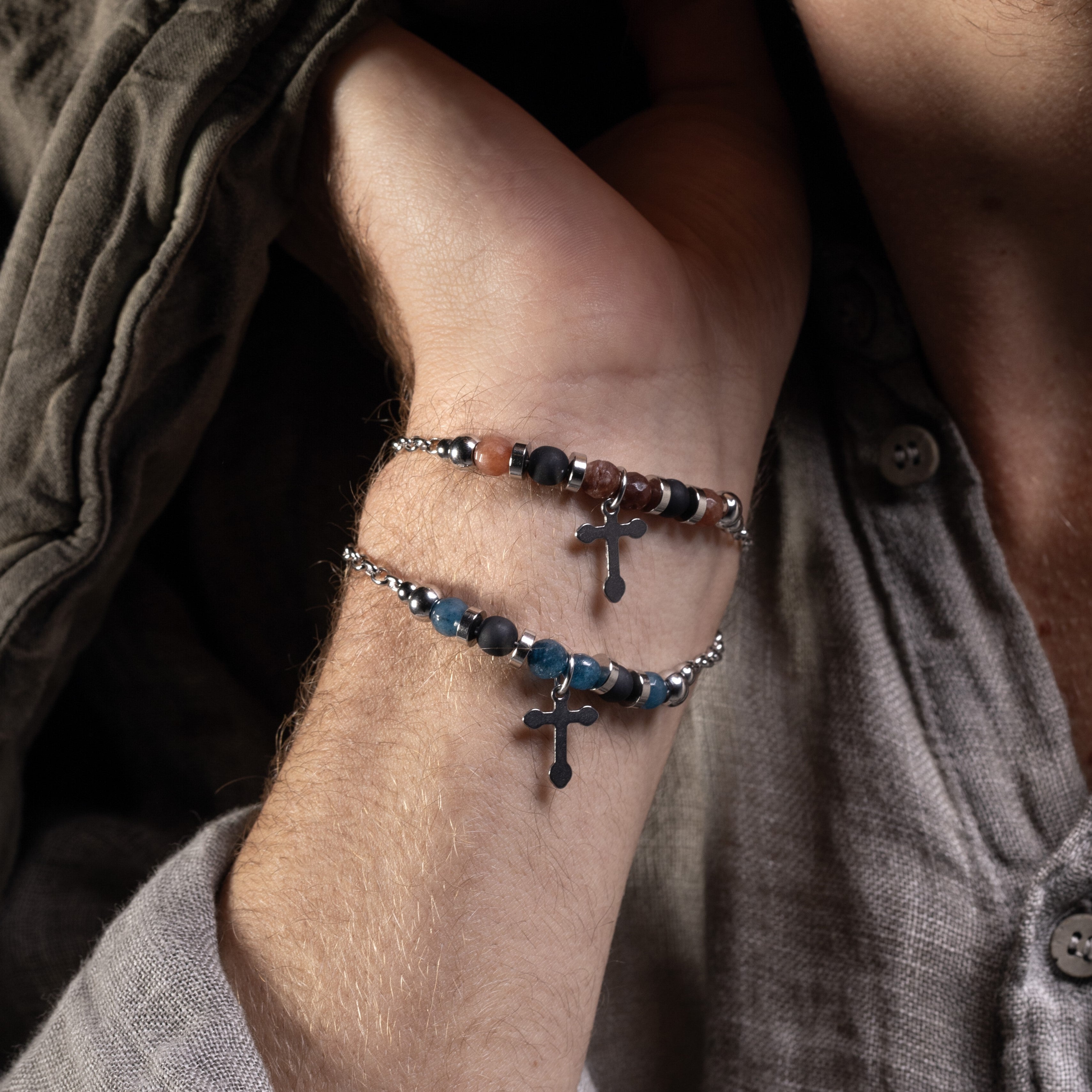 Stain Collection - Close-up of a person's wrist wearing Murano Glass two beaded bracelets with cross designs.