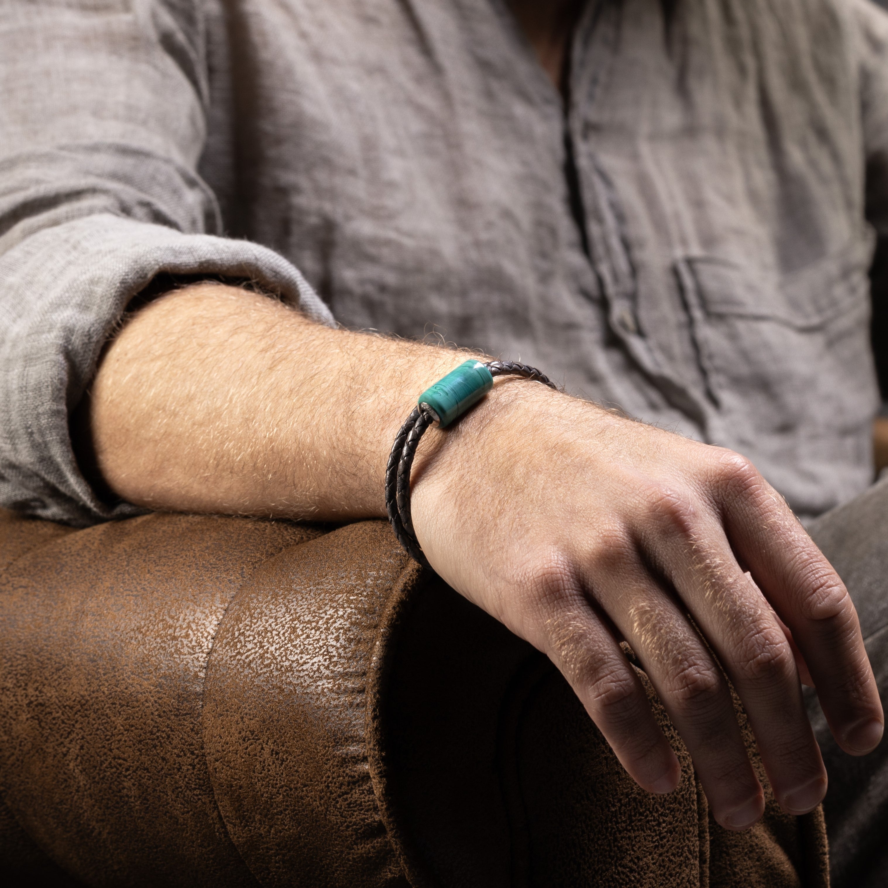 Tag Collection - Murano Glass - Person wearing a turquoise bracelet on a brown leather couch