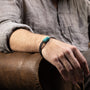 Tag Collection - Murano Glass - Person wearing a turquoise bracelet on a brown leather couch