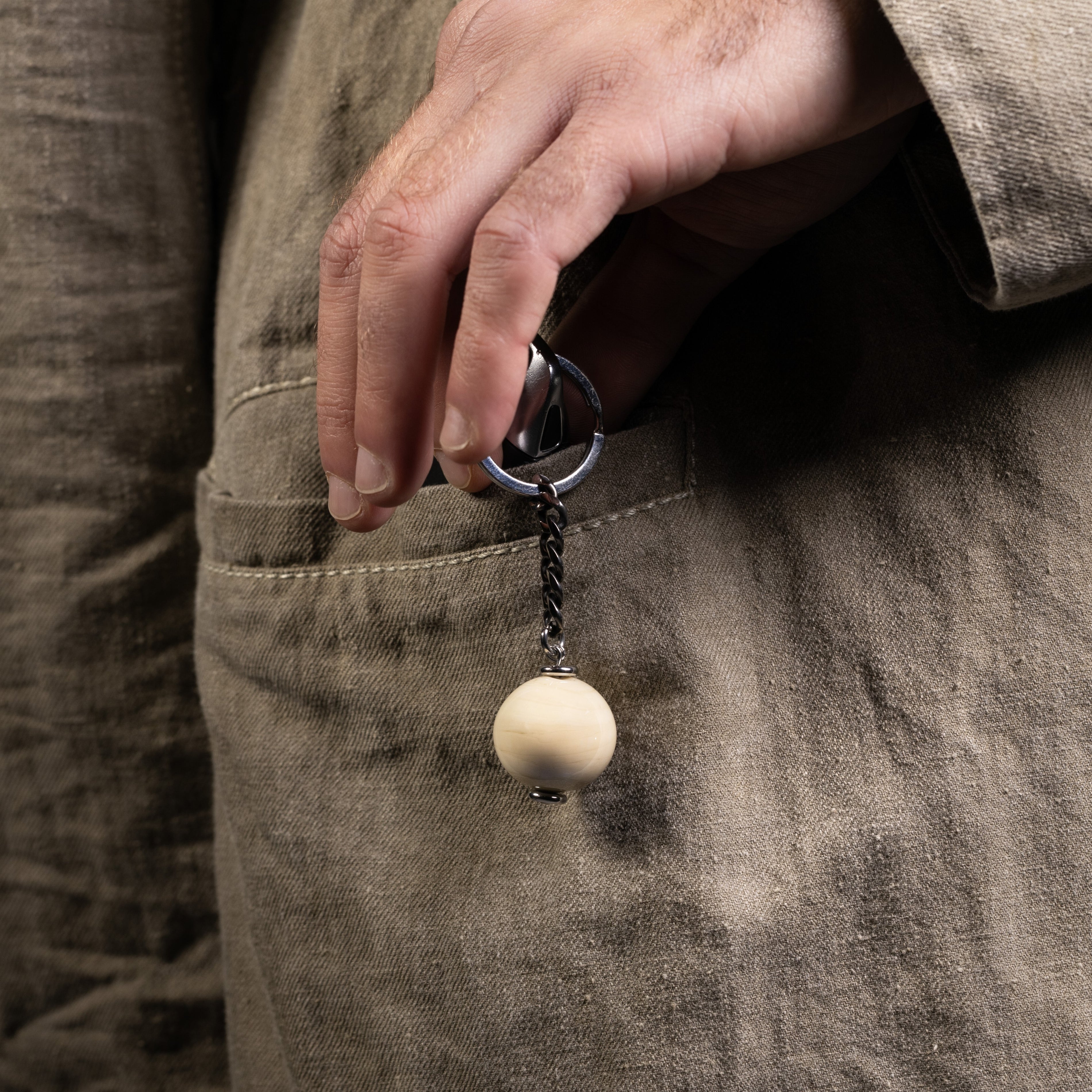 Chunk Collection Murano glass men's keychain, stainless steel and brass with rhodium finish, 9 cm length, handcrafted in Venice, Italy. attached to a pocket.