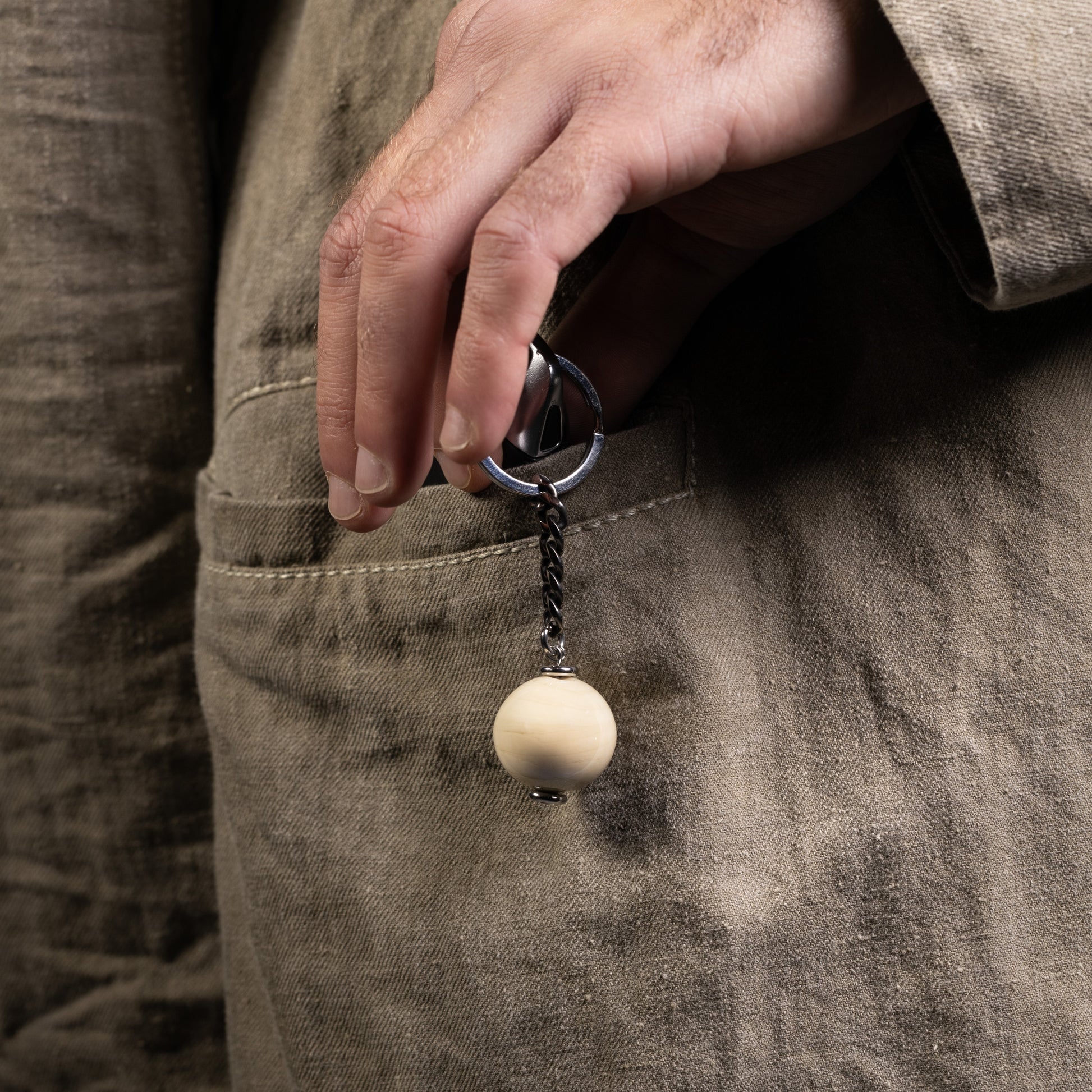 Chunk Collection Murano glass men's keychain, stainless steel and brass with rhodium finish, 9 cm length, handcrafted in Venice, Italy. attached to a pocket.