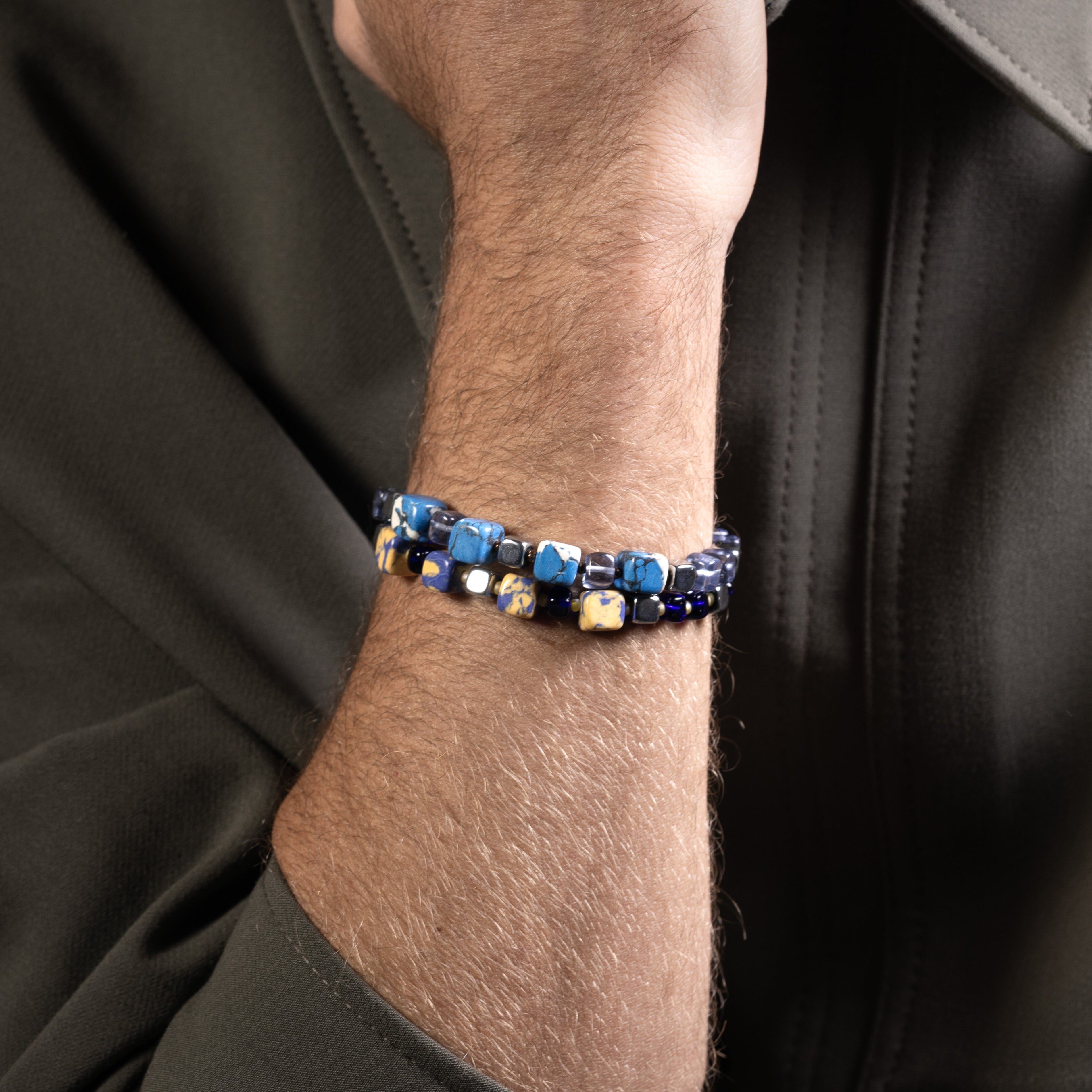 Close-up of a wrist wearing Flux Collection men’s bracelet with ceramic cubes, hematite beads and rhodium finish over stainless steel and brass, 20 cm length.