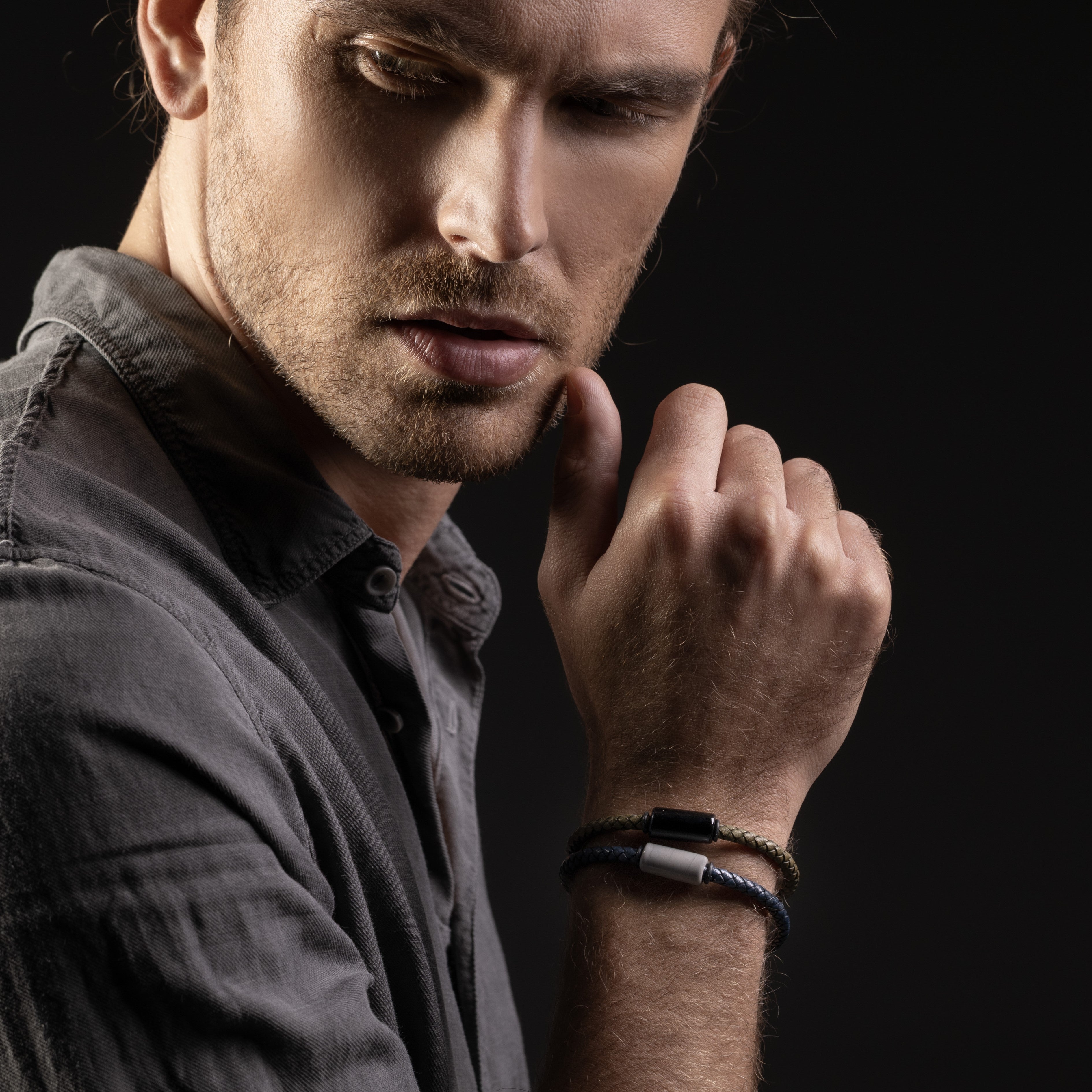 Man wearing a Grit Collection men’s bracelet with Murano glass, braided leather, steel and brass, rhodium finish, 20 cm length.