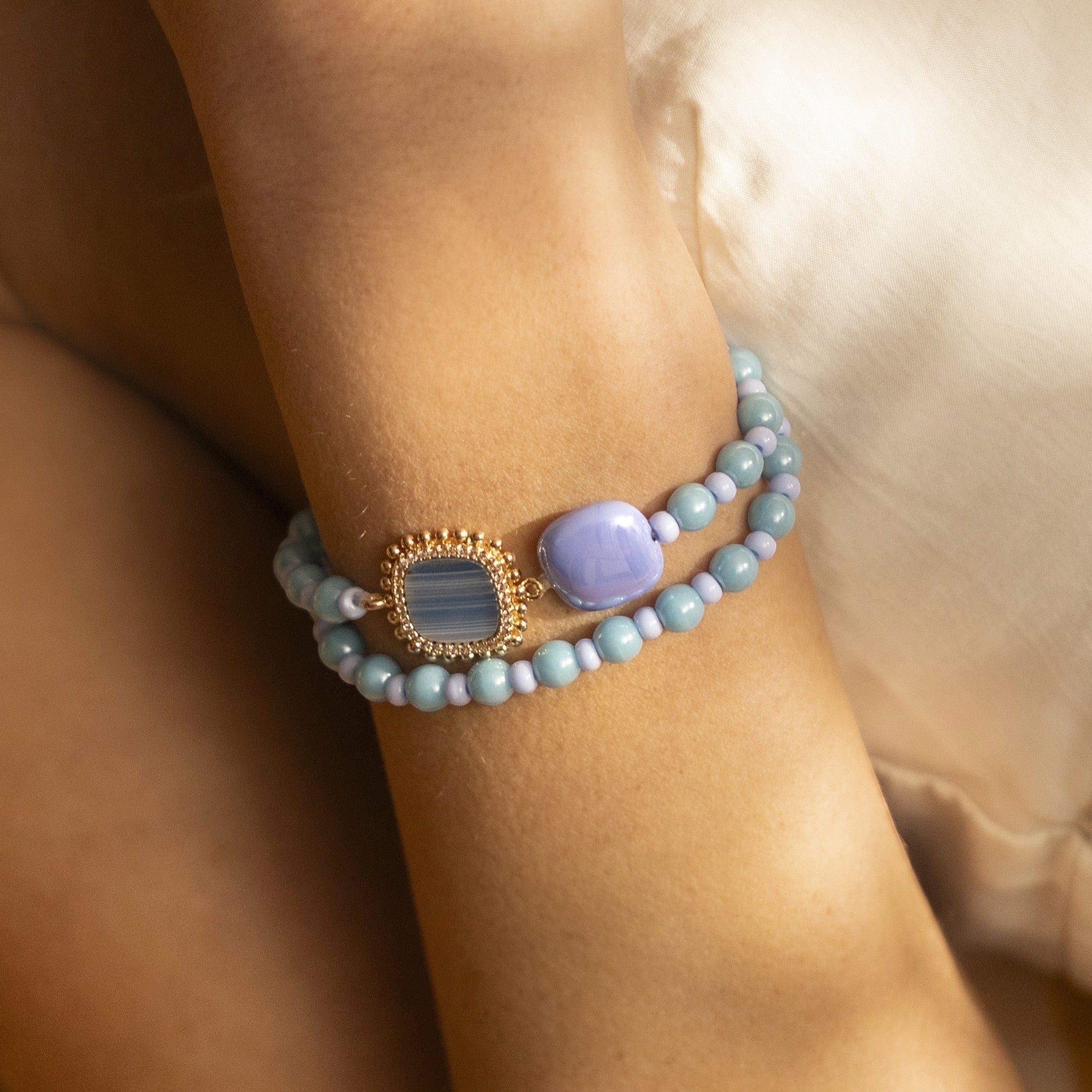 Close-up of a wrist wearing Bloom Murano glass bracelet with Carnelian, Agate or Amazonite stones and brass components, 18KT Gold Finish, adjustable, handcrafted in Venice, Italy.