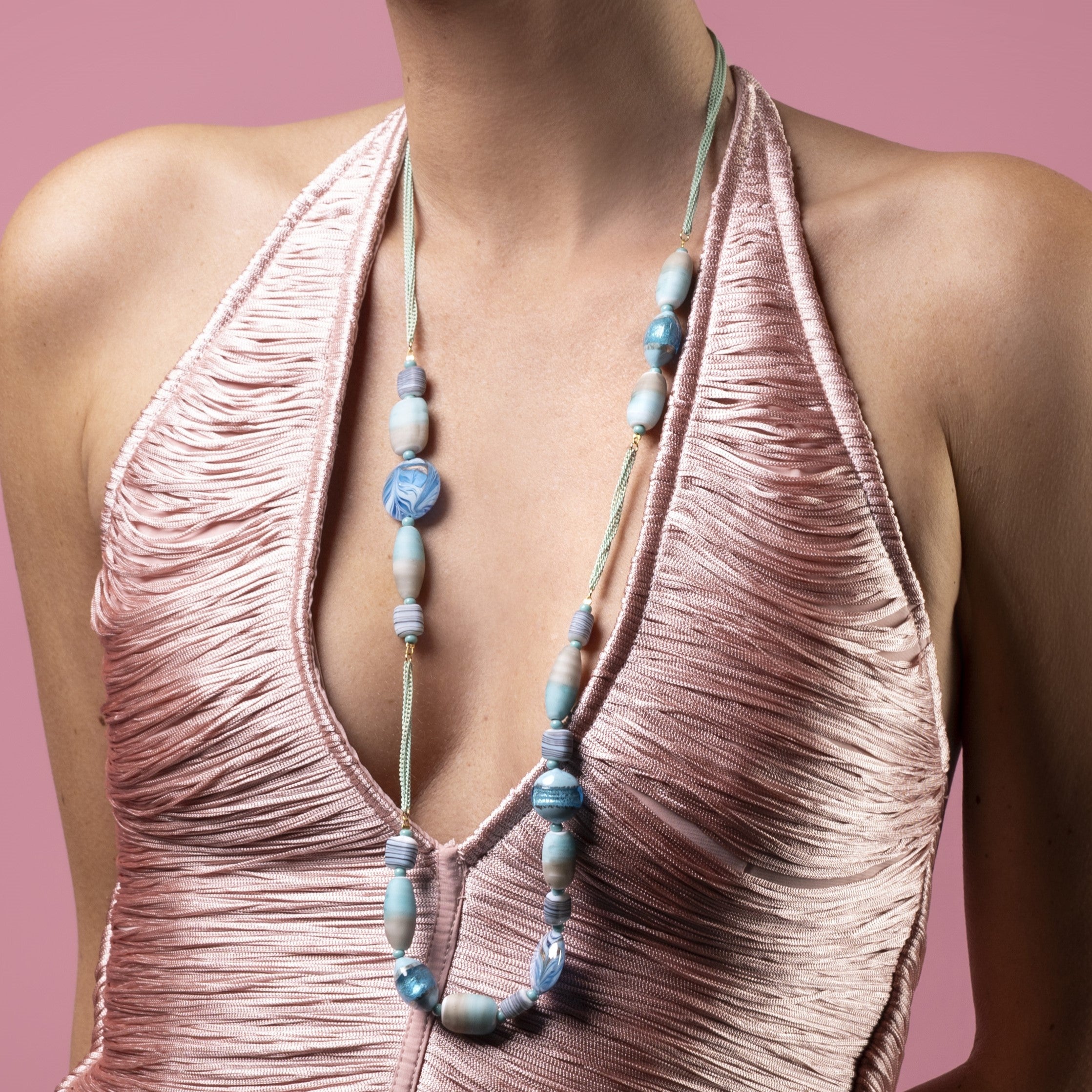 Woman wearing a pink halter top with a Blush Murano glass opera necklace with 18KT Gold Finish over brass, 31.5 inches long, handcrafted in Venice, Italy.