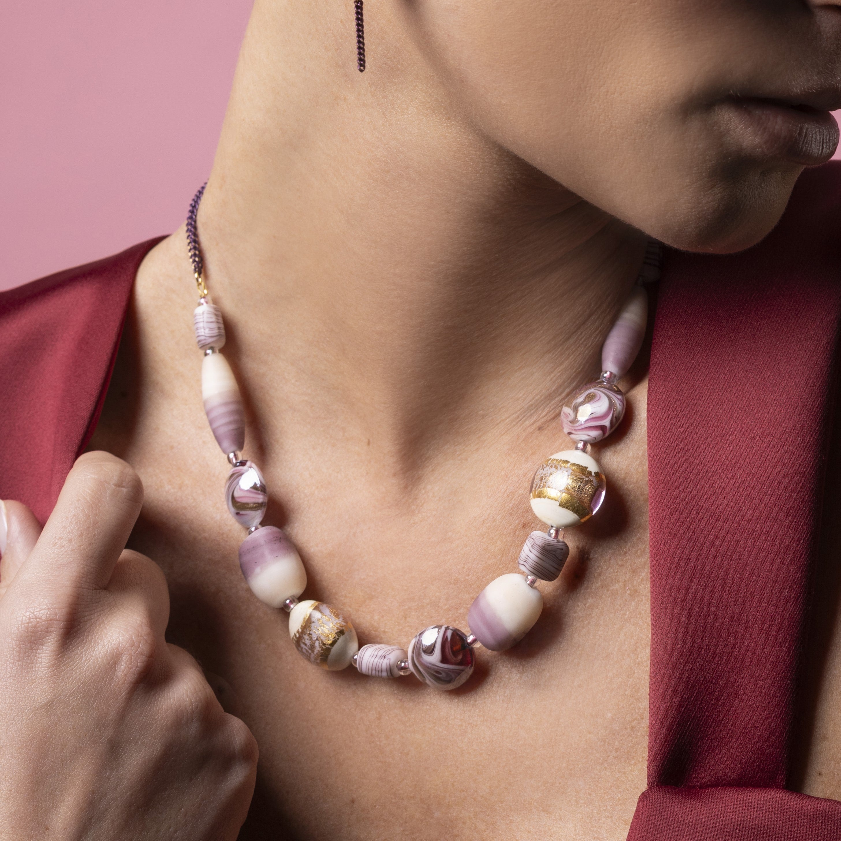 Blush Murano glass choker with 18KT Gold Finish over brass, adjustable 17.7 inches with 2 inch extension, handcrafted in Venice, Italy. worn by a person against a pink background
