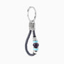 Flare Collection men's keychain with Murano glass, braided leather, rhodium finish over stainless steel, brass and silicone details, 10 cm length — angled view.