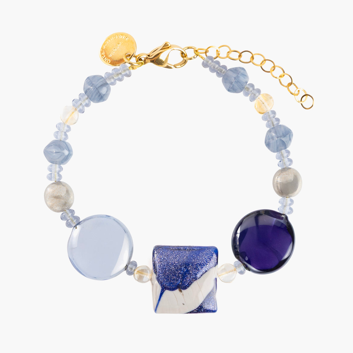 MurrinaMurano.us Easy Bracelet in blue Murano Glass, featuring translucent blue beads, purple accents, and a faceted blue-and-white centerpiece with gold-finished details. Handcrafted in Italy.