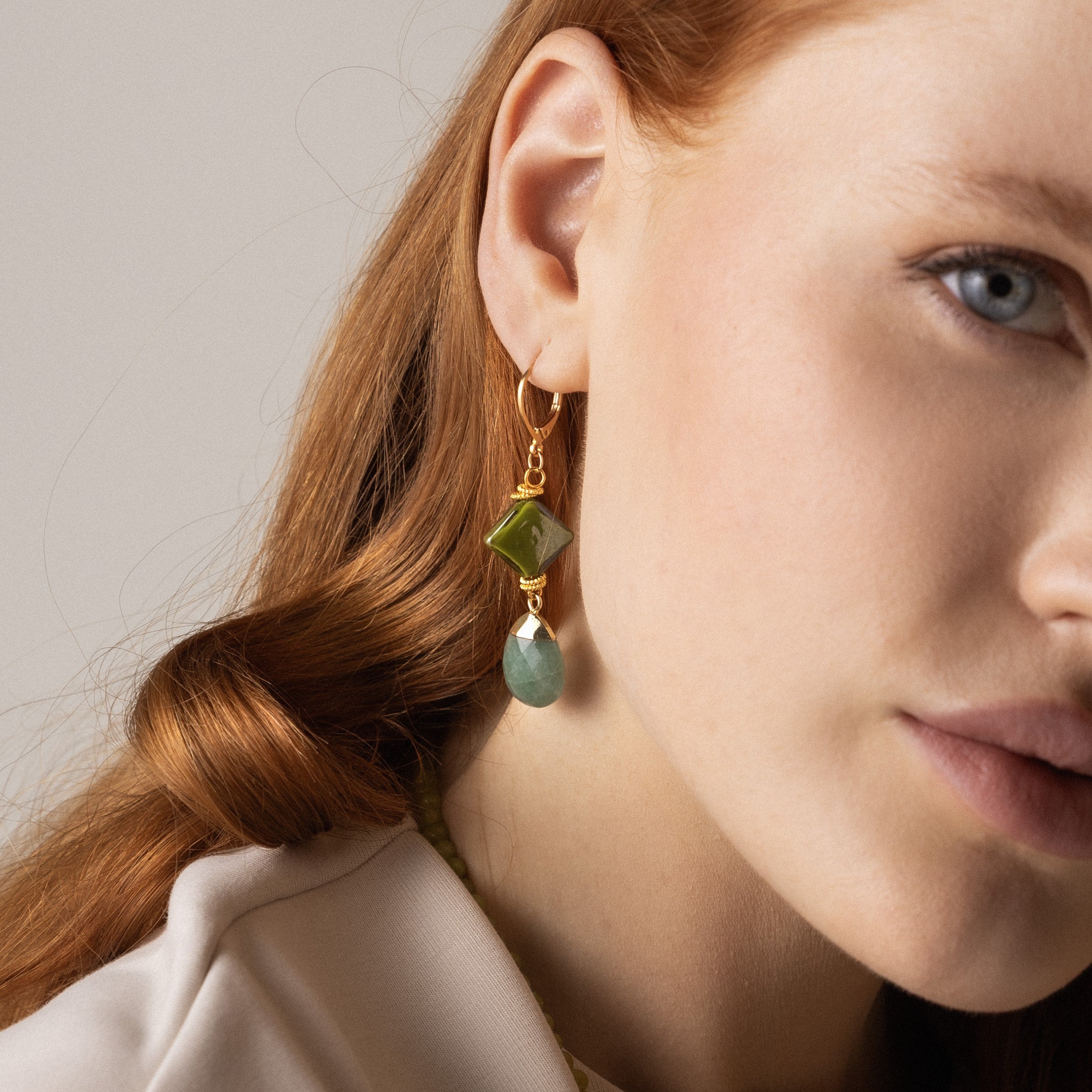 MurrinaMurano.us model wearing Veil Murano glass drop earrings in green with faceted natural stone drops and 18KT gold-plated brass. Handcrafted in Italy.