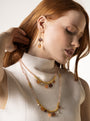 MurrinaMurano.us model wearing Veil Murano glass drop earrings in orange with peachy natural stone drops and 18KT gold-plated brass. Handcrafted in Italy.