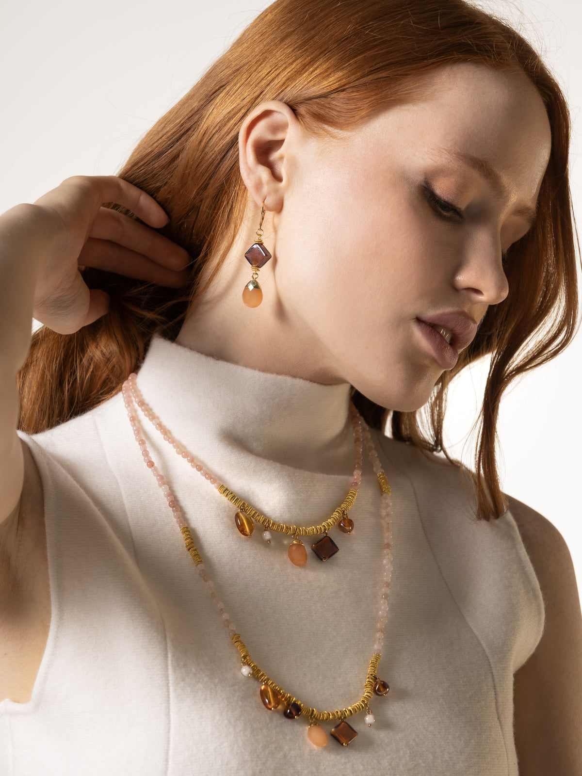 MurrinaMurano.us model wearing Veil Murano glass drop earrings in orange with peachy natural stone drops and 18KT gold-plated brass. Handcrafted in Italy.