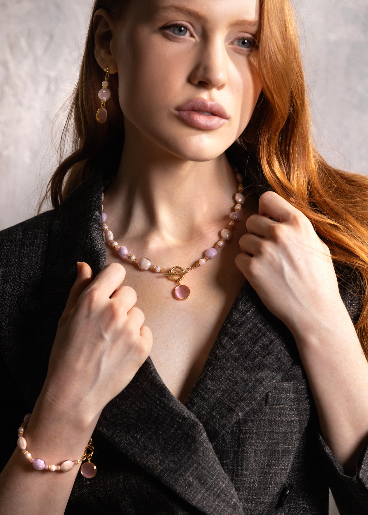 Woman wearing a MurrinaMurano.us Trace Choker Necklace in pink, featuring rounded Murano Glass beads, pale accents, and a central pink glass pendant with gold-finished details. Handcrafted in Italy.