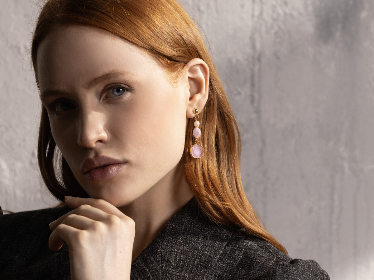 MurrinaMurano.us model wearing a pink Trace Drop Earring, showcasing the layered rounded glass design and large faceted pendant below the earlobe. Handcrafted in Italy.