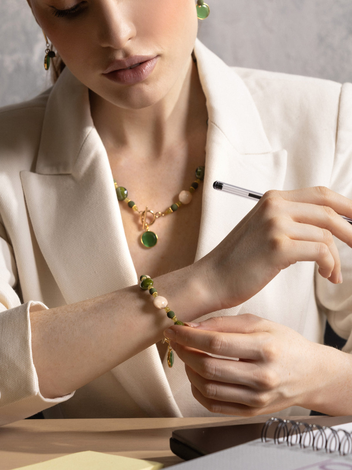 MurrinaMurano.us model wearing a green Trace Bracelet with luminous Murano Glass beads, contrasting pale accents, and a distinctive toggle clasp with matching glass pendant. Handcrafted in Italy.