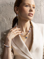 Woman wearing the MurrinaMurano.us Trace Choker Necklace in blue, with luminous blue Murano Glass beads, pale accents, and a gold-finished central pendant. Handcrafted in Italy.