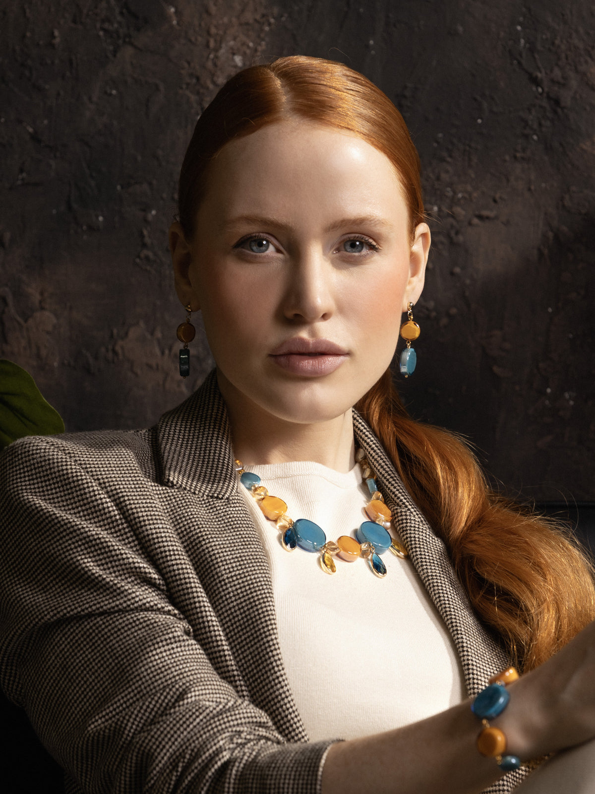 Woman wearing Edge Murano glass drop earrings with blue and orange glass elements, 18KT Gold Finish over brass, handcrafted in Italy.