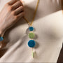 MurrinaMurano.us Murano glass pendant necklace with blue and green glass elements and faceted green pendant, 18KT gold finish over brass.