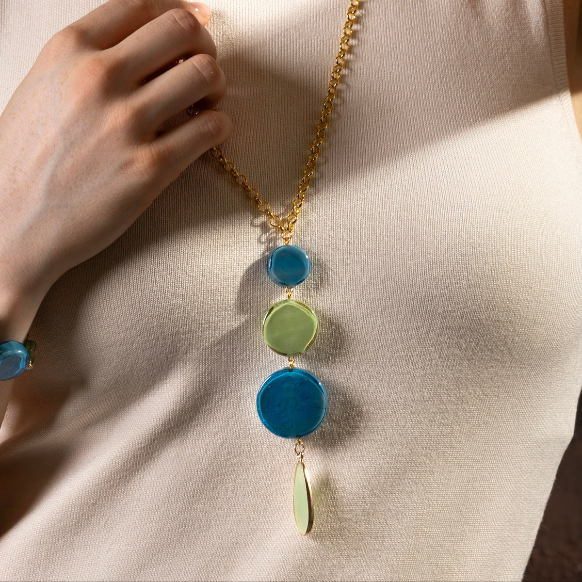 MurrinaMurano.us Murano glass pendant necklace with blue and green glass elements and faceted green pendant, 18KT gold finish over brass.