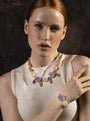 Woman wearing the Edge Murano glass bracelet with lilac and cream colored glass elements and gold finish details, handcrafted in Italy.