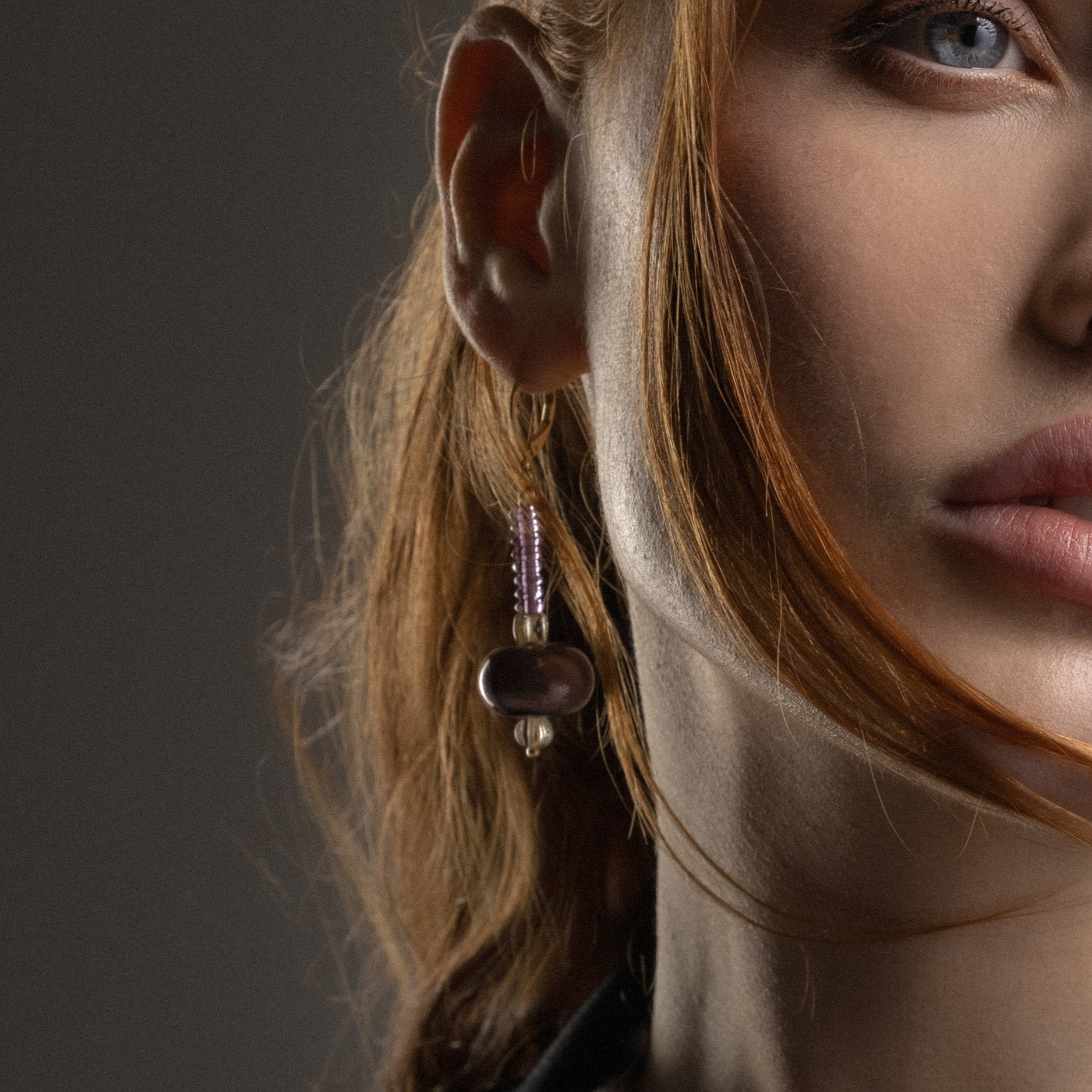 Close-up of a model wearing MurrinaMurano.us Frame drop earrings in pink Murano Glass, highlighting the delicate beaded drop and luminous sculptural glass centerpiece. Handcrafted in Italy.