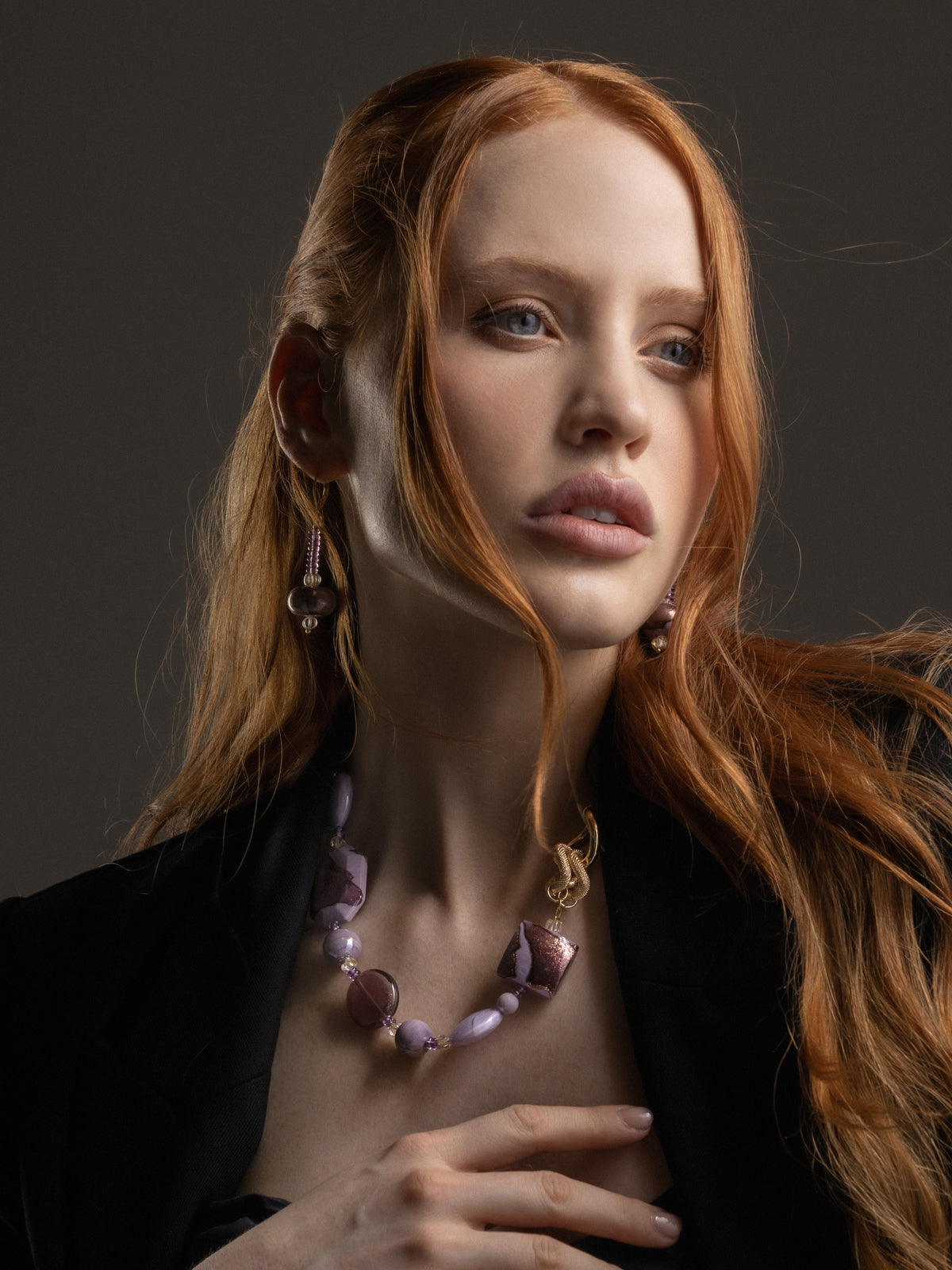 MurrinaMurano.us Frame earrings in pink Murano Glass worn by a model, showcasing the elongated drop silhouette and layered glass detailing against a dark ensemble. Handcrafted in Italy.