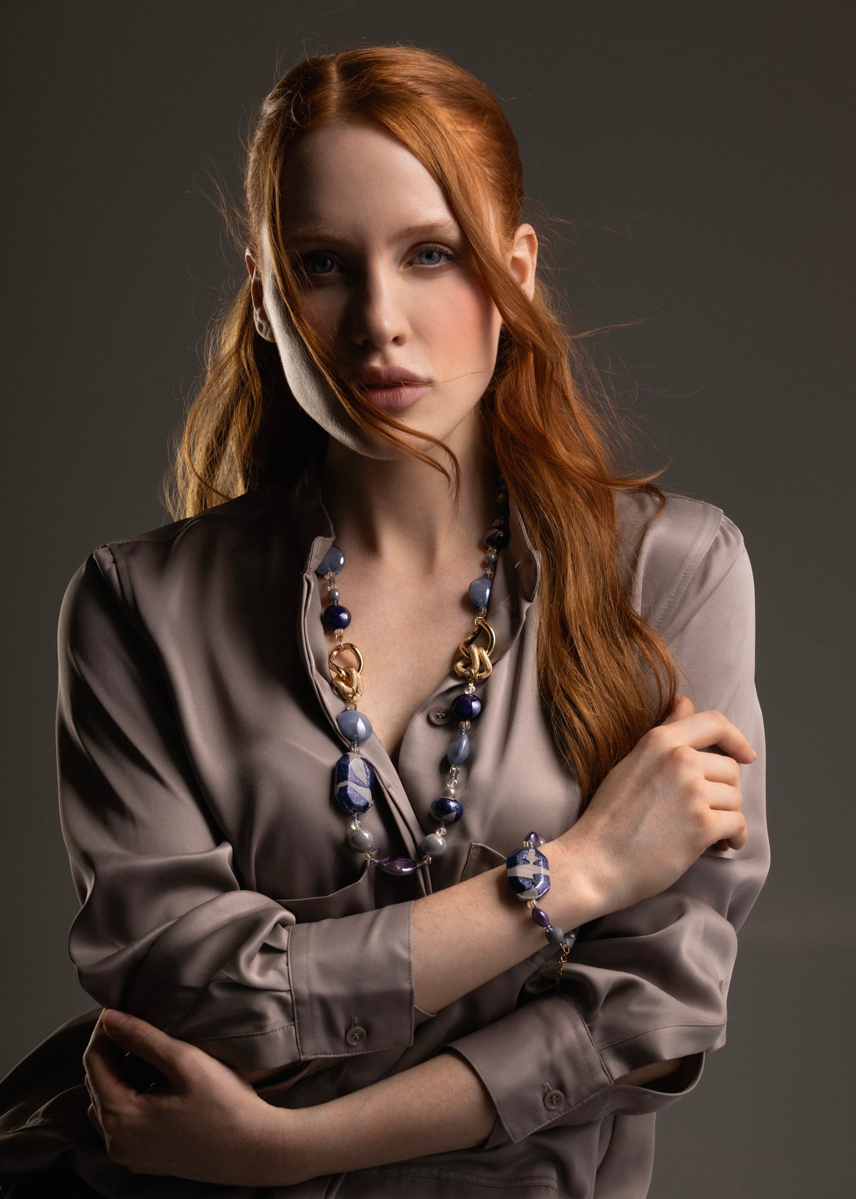 MurrinaMurano.us blue Frame Opera Necklace styled on a model, highlighting the contrast between translucent blue glass, deep violet accents, and textured gold-finished links. Handcrafted in Italy.