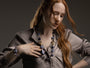 Close view of a woman wearing the blue Frame Murano Glass Bracelet, highlighting the layered glass beads, polished metal accents, and architectural centerpiece. Handcrafted in Italy.