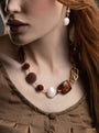 MurrinaMurano.us model wearing the brown Frame Choker Necklace and earrings with deep amber, brown, and cream Murano Glass elements and sculptural gold-finished metal links. Handcrafted in Italy.