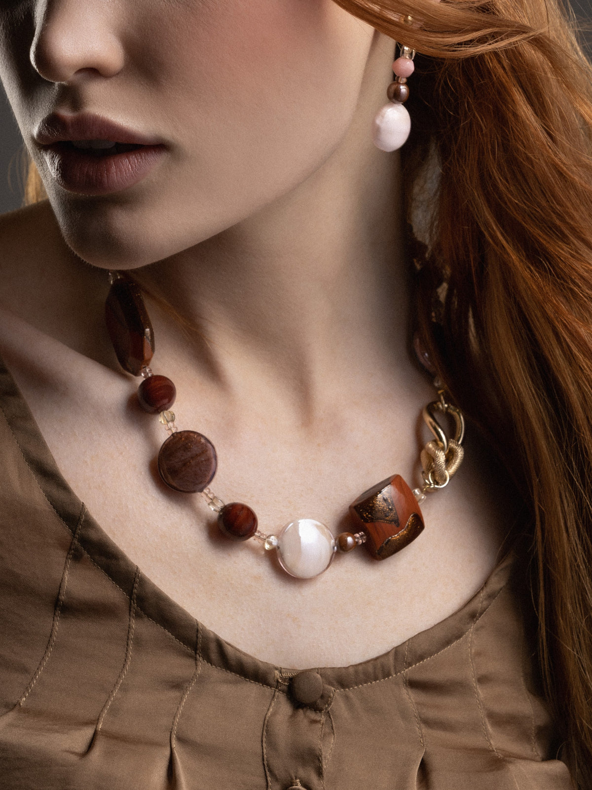 MurrinaMurano.us model wearing the brown Frame Choker Necklace and earrings with deep amber, brown, and cream Murano Glass elements and sculptural gold-finished metal links. Handcrafted in Italy.