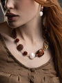MurrinaMurano.us model wearing Frame earrings in rich brown Murano Glass, with a delicate vertical arrangement of translucent beads and luminous oversized glass drops. Handcrafted in Italy.