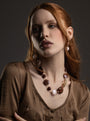 MurrinaMurano.us model wearing the brown Frame Choker Necklace with deep amber, brown, and cream Murano Glass elements and sculptural gold-finished metal links. Handcrafted in Italy.