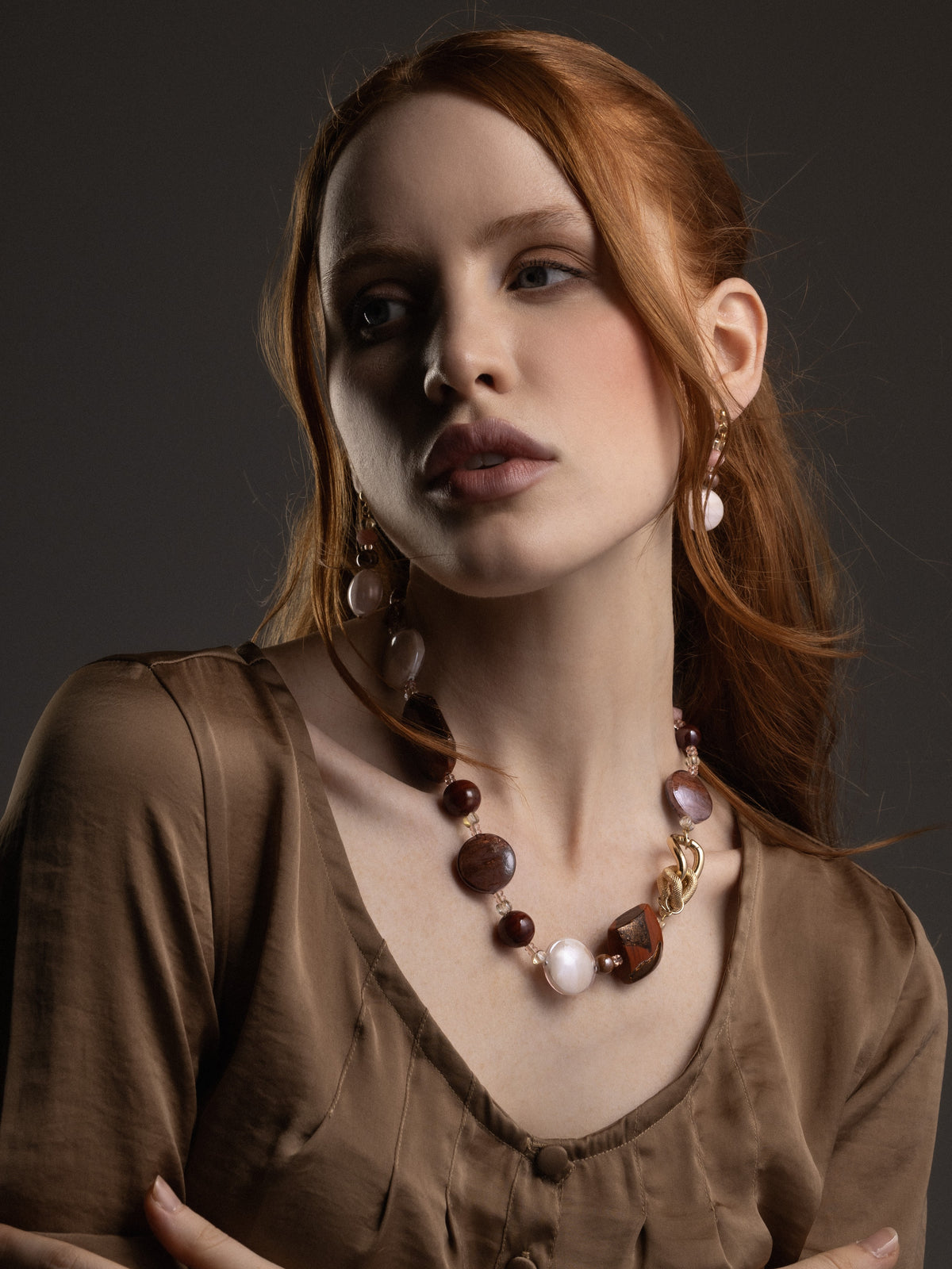 MurrinaMurano.us model wearing the brown Frame Choker Necklace with deep amber, brown, and cream Murano Glass elements and sculptural gold-finished metal links. Handcrafted in Italy.